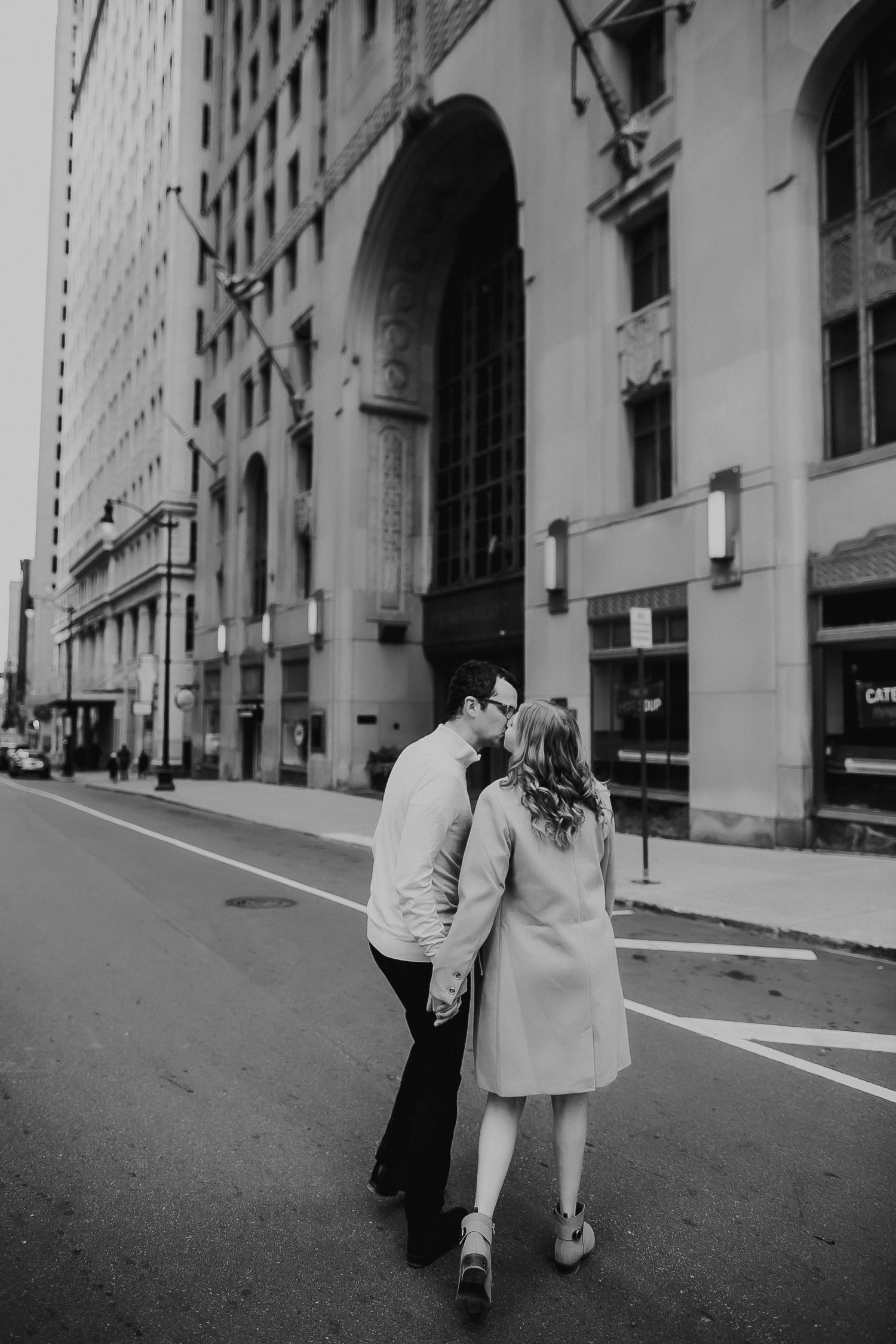 A black and white photo sequence showing a couple's playful interaction on a city street.