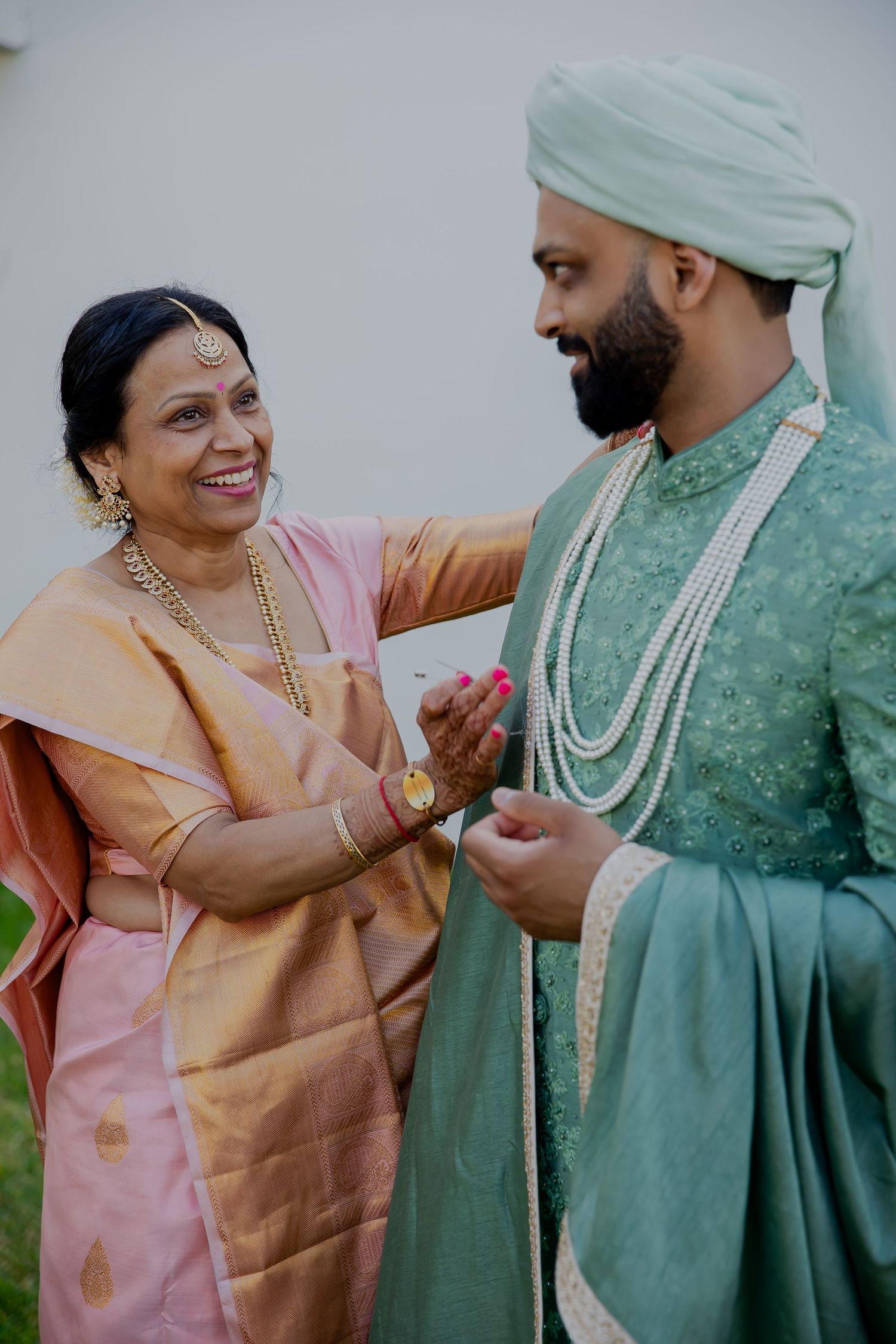Candid moment showing traditional Indian wedding attire and joyful interaction.