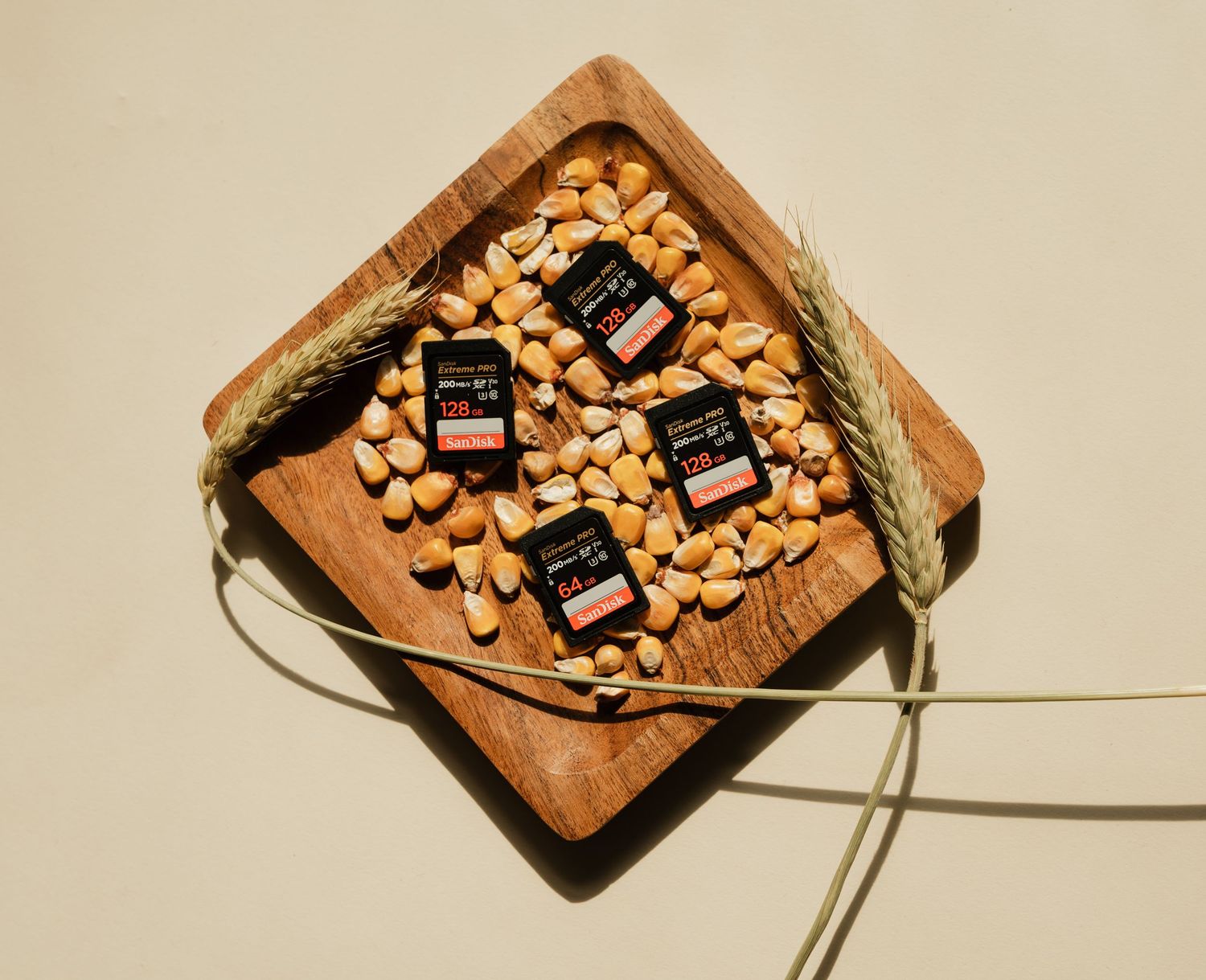 A wooden cutting board with scattered cashews and a jar of honey being drizzled across the surface.