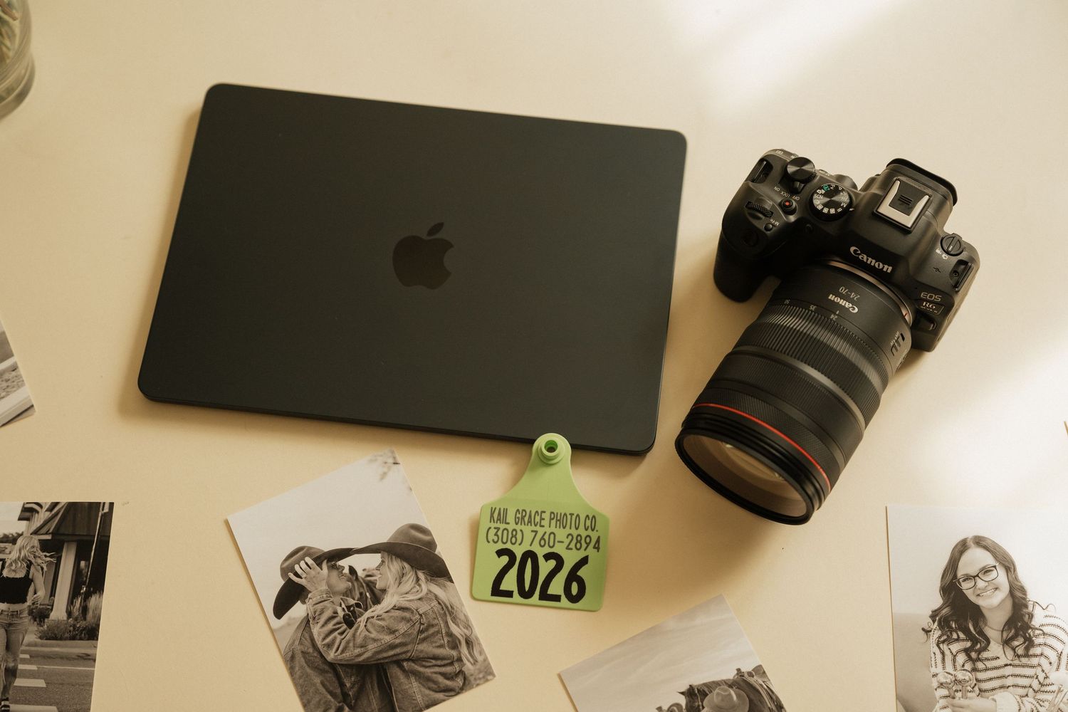 Workspace setup with camera equipment, Apple devices, and photography gear arranged on a desk surface.
