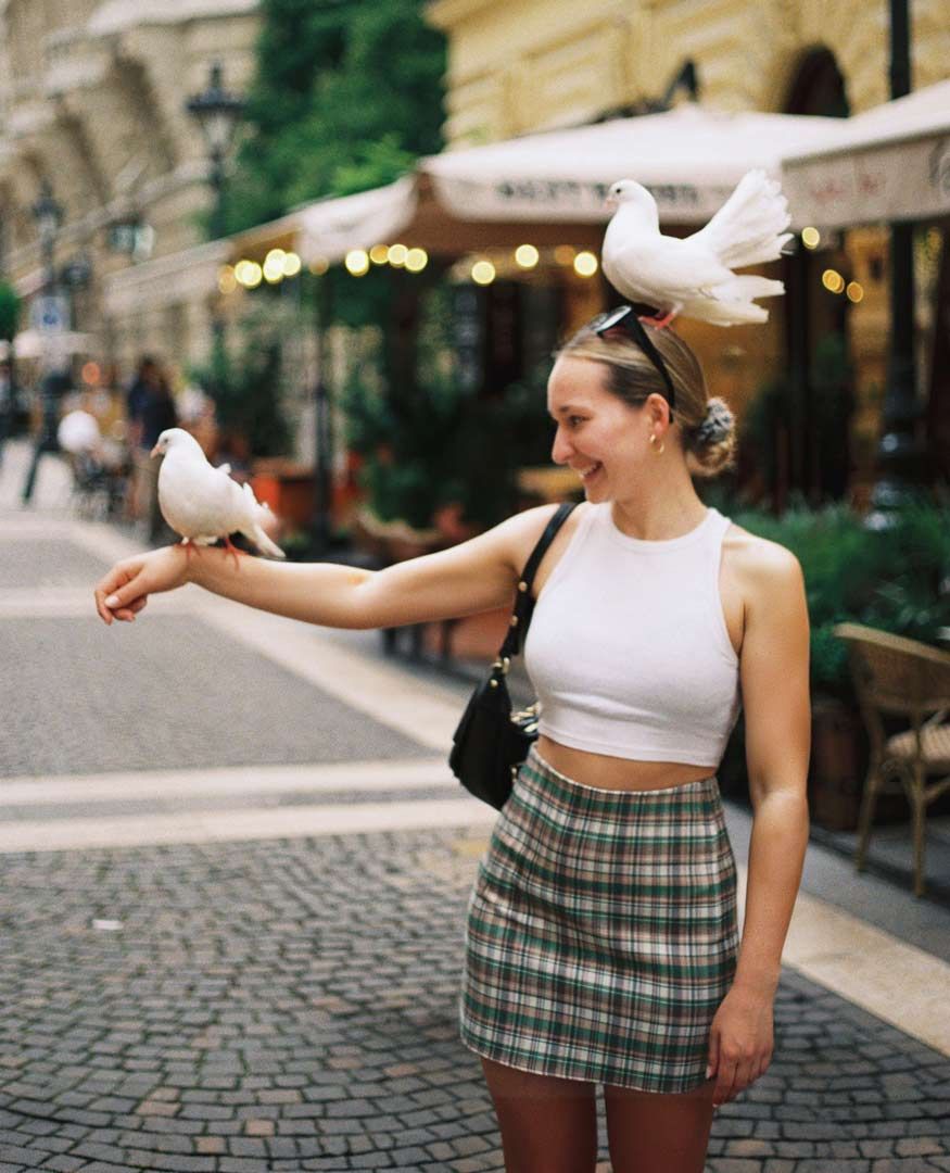 Lifestyle Portrait von Vero in Budapest mit weißen Tauben als Kulisse.