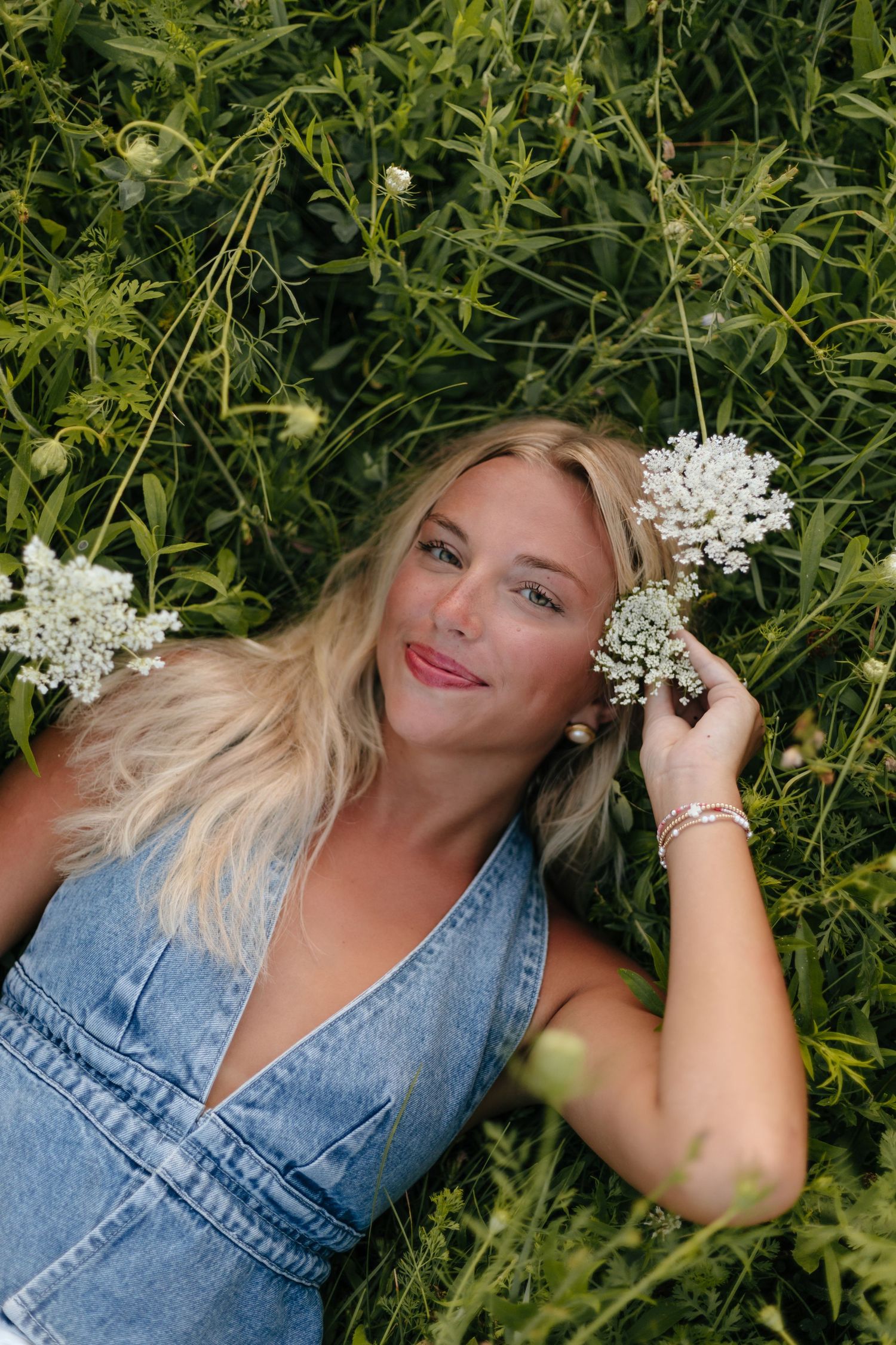 Creative portrait in tall grass with white baby's breath flowers as hair accessories.