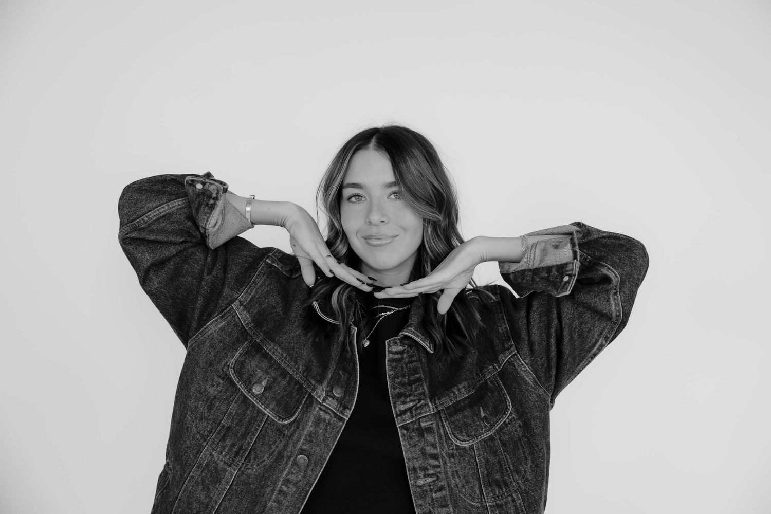 Black and white studio portraits showing joyful expressions in denim jacket.