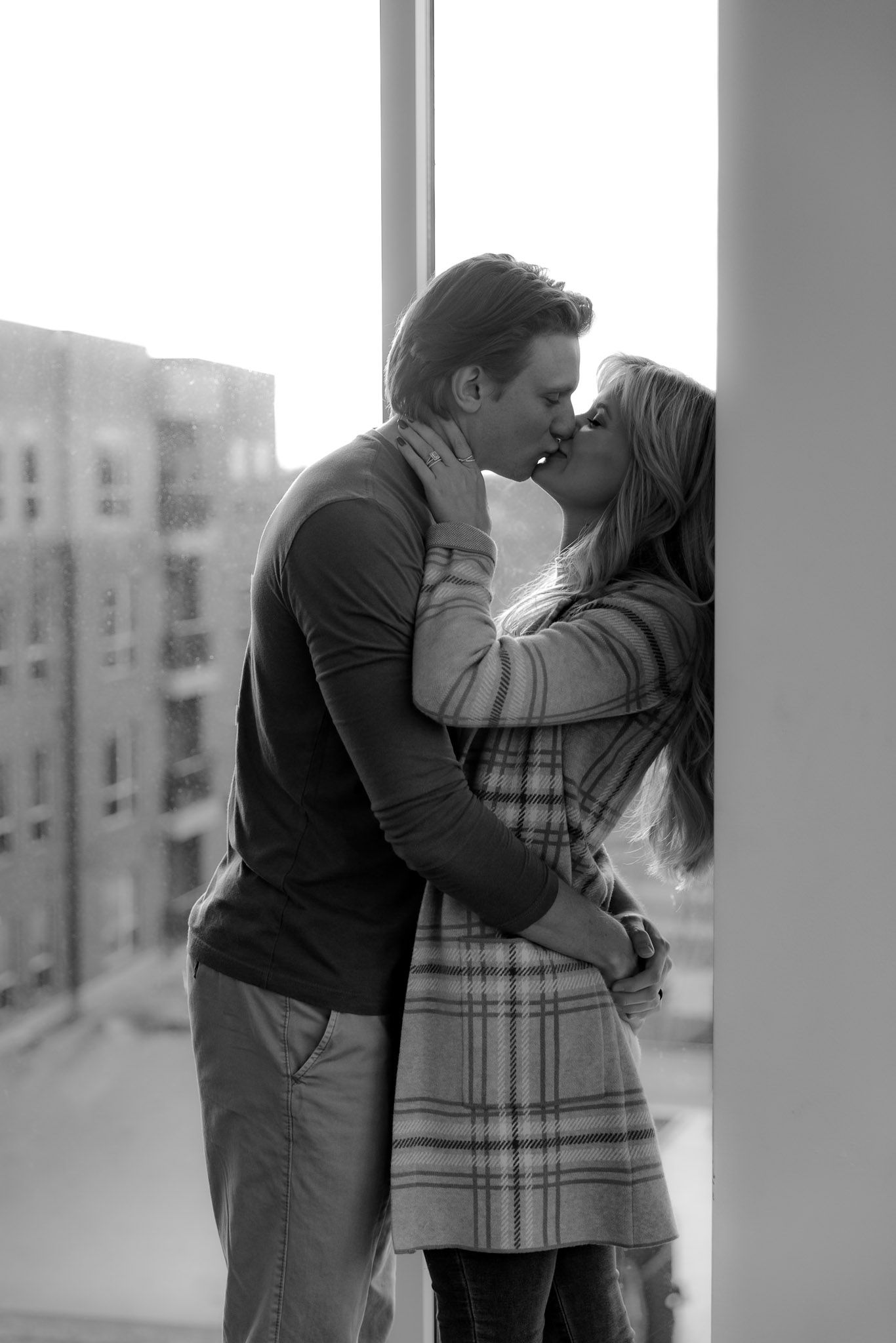 A romantic black and white sequence shows a couple sharing a tender kiss by a window.