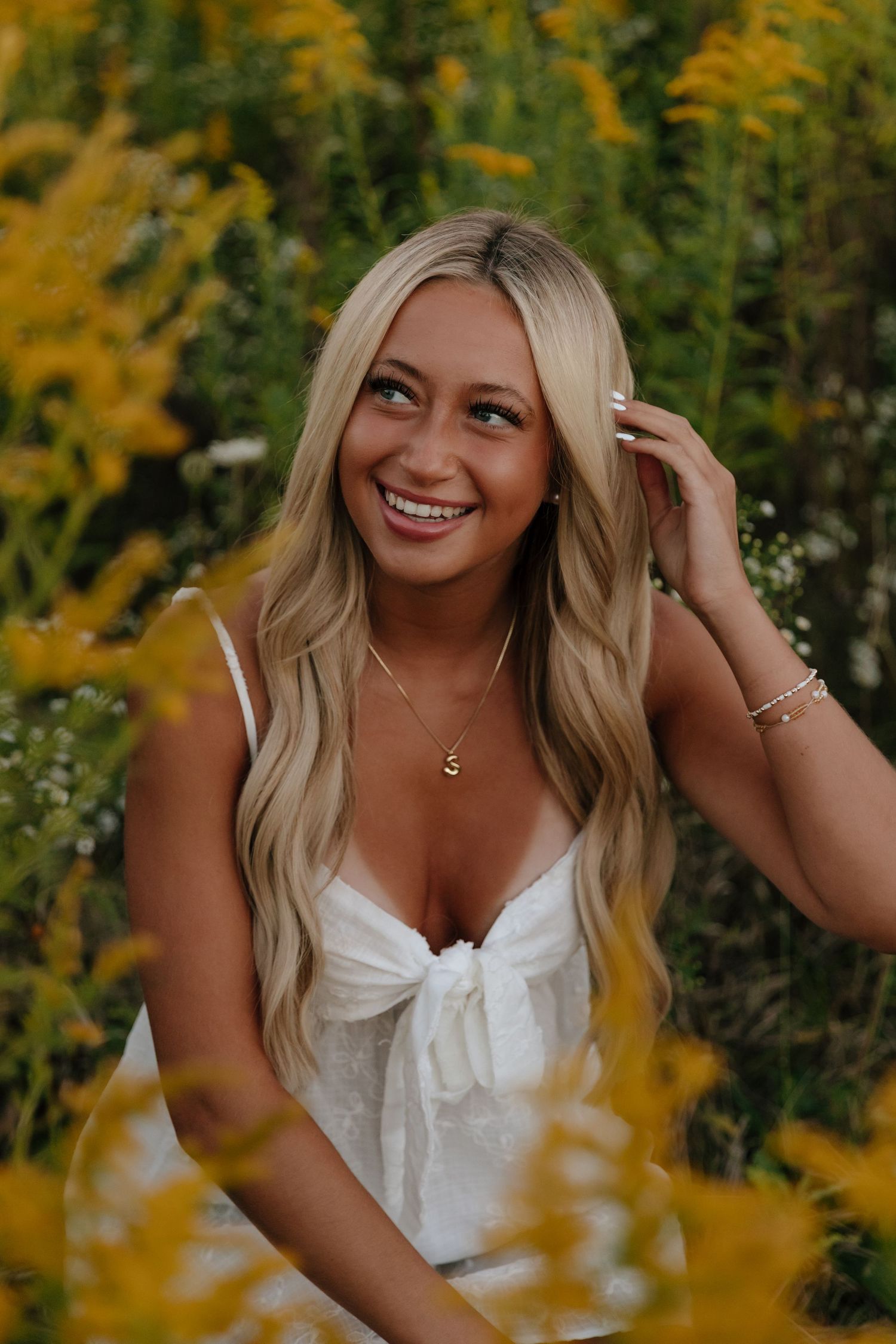 A series of outdoor portrait photos with yellow wildflowers and greenery creating a warm autumn backdrop.