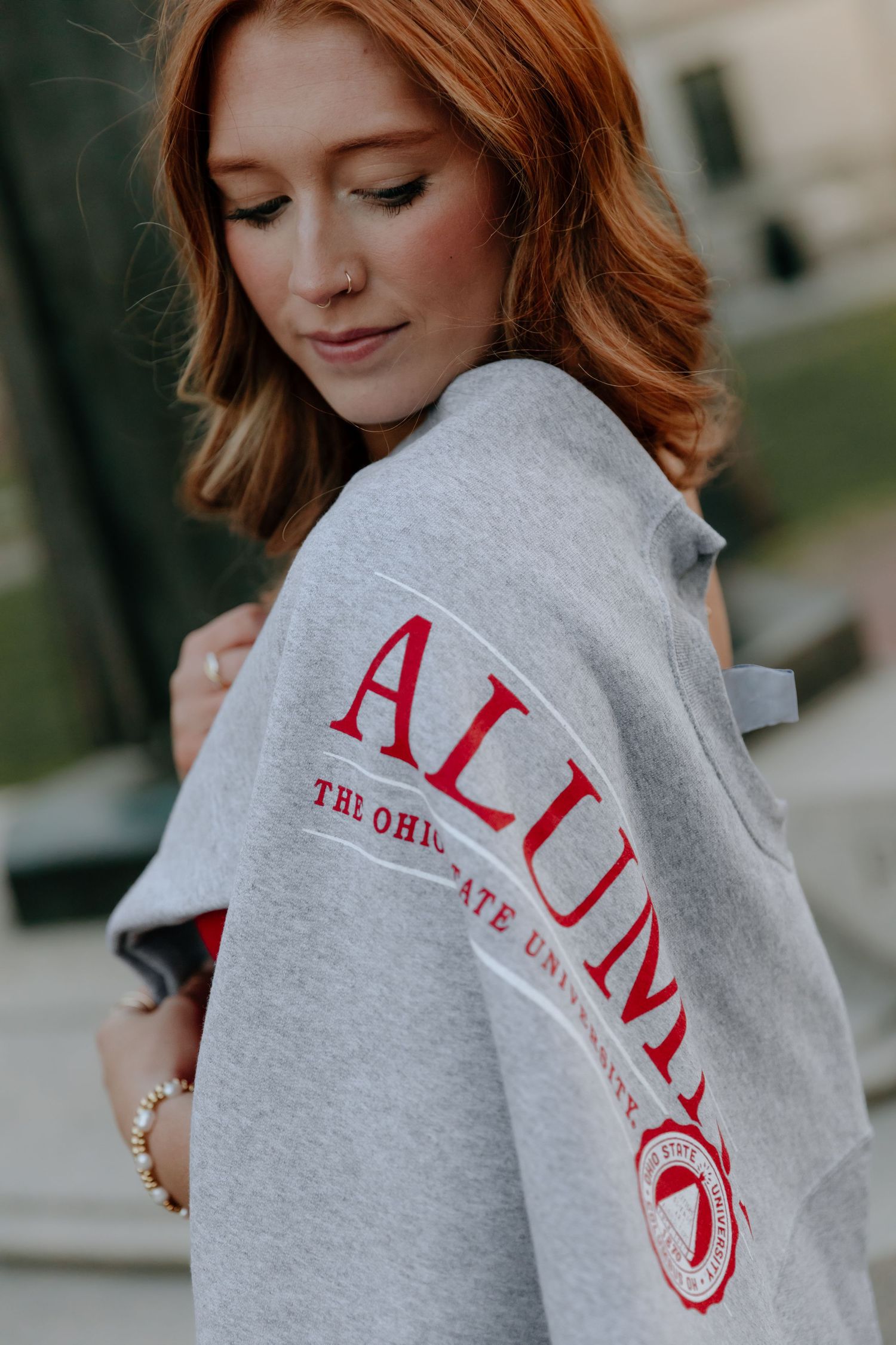 Someone wearing a cozy grey sweatshirt with red lettering visible on the sleeve.