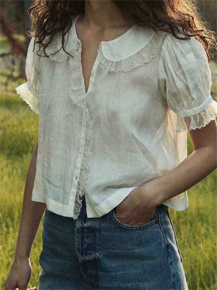 Vintage-inspired white cotton blouse with peter pan collar and puff sleeves paired with classic blue jeans in outdoor setting.