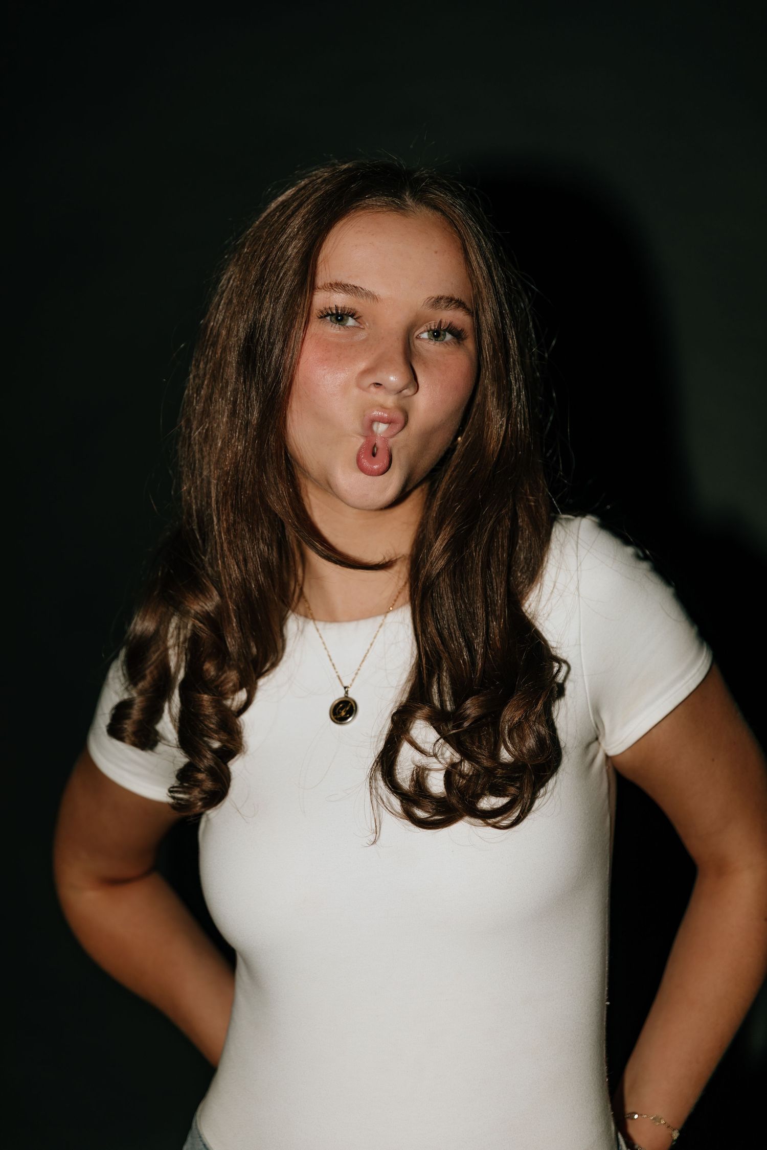 A person in a white t-shirt poses playfully against a dark background in a series of connected photos.