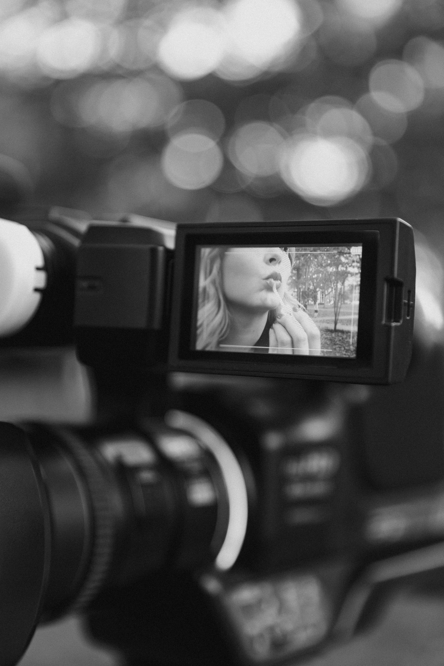 Professional video camera viewfinder display showing a black and white preview image in a studio setting.