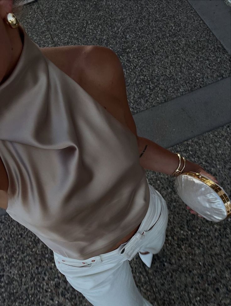 A close-up sequence showing a person's arm wearing a beige sweater and white sleeve cuff with jewelry details.