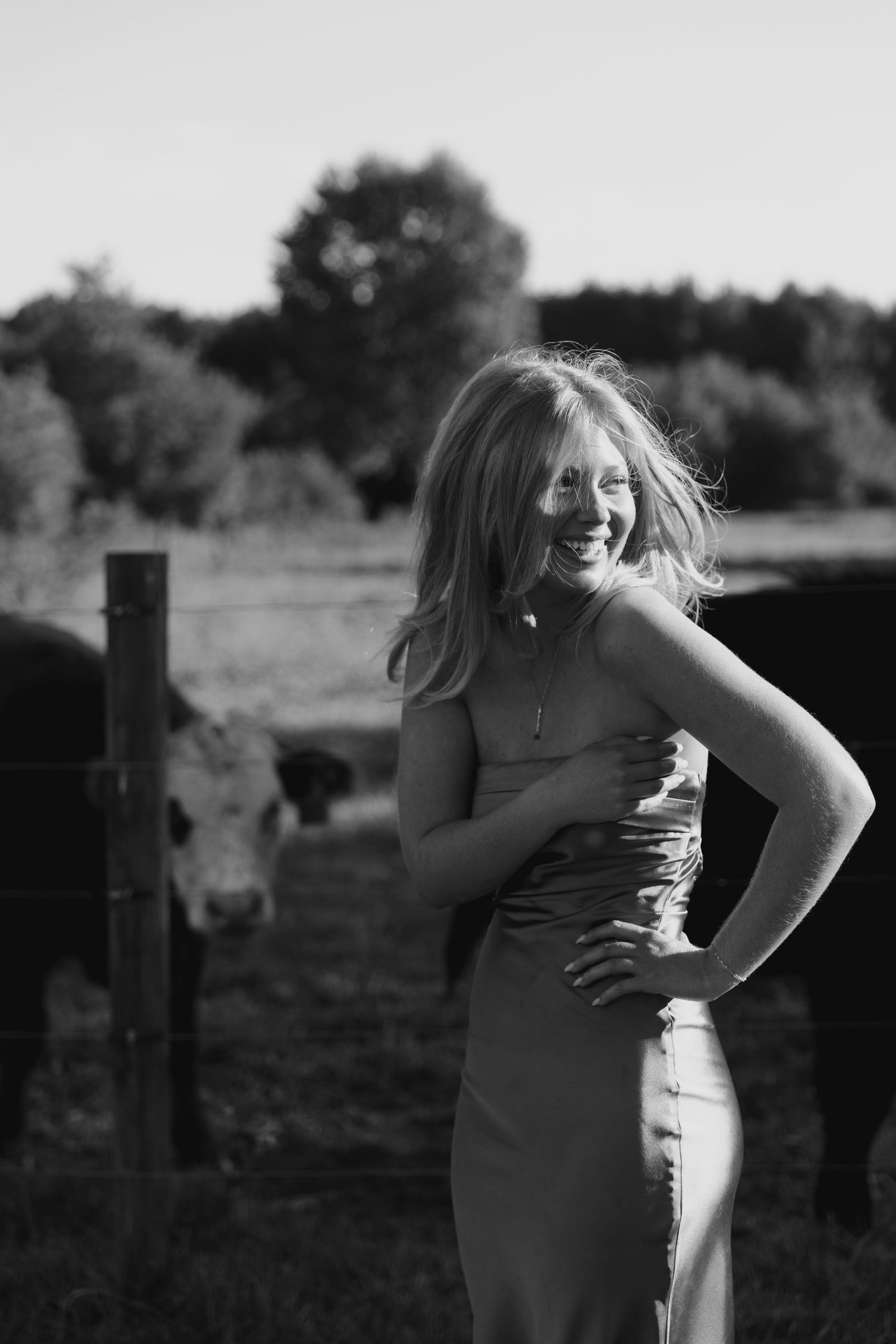 A black and white photo sequence showing a person in a dress posing outdoors against a rural backdrop.
