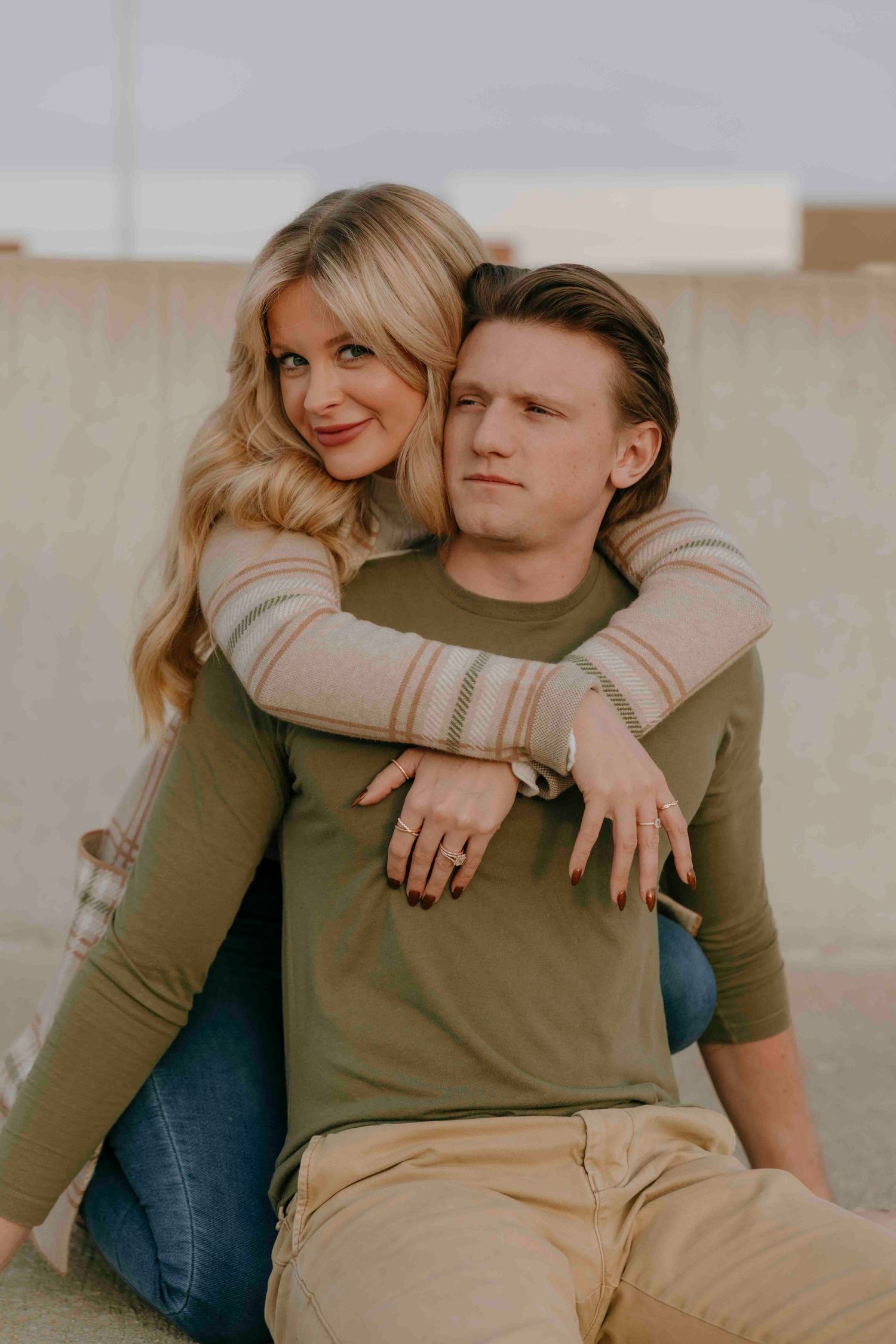Casual couple portraits in neutral tones showing affectionate poses against a light background.