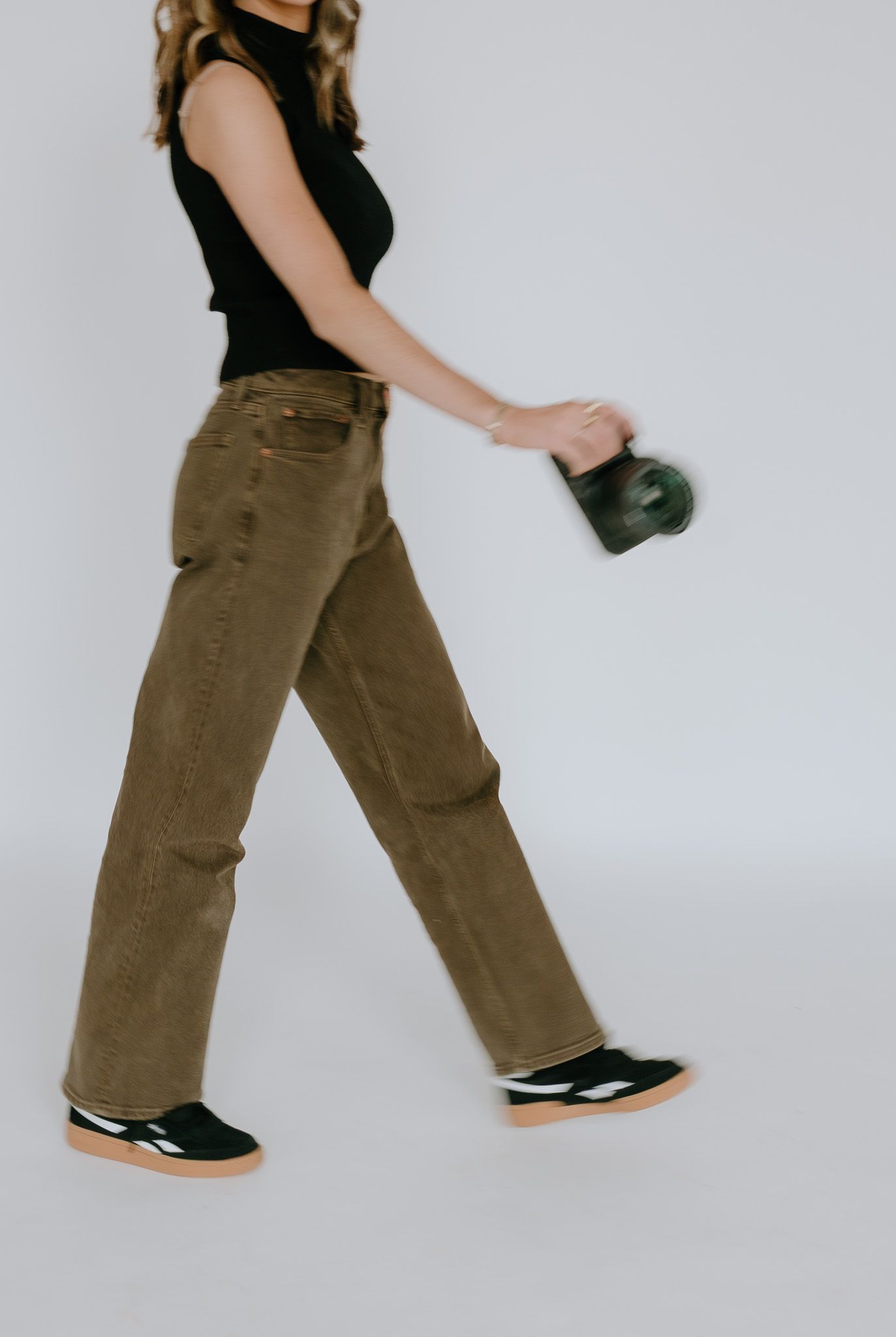 Series showing legs walking in brown pants and black shoes against white background.