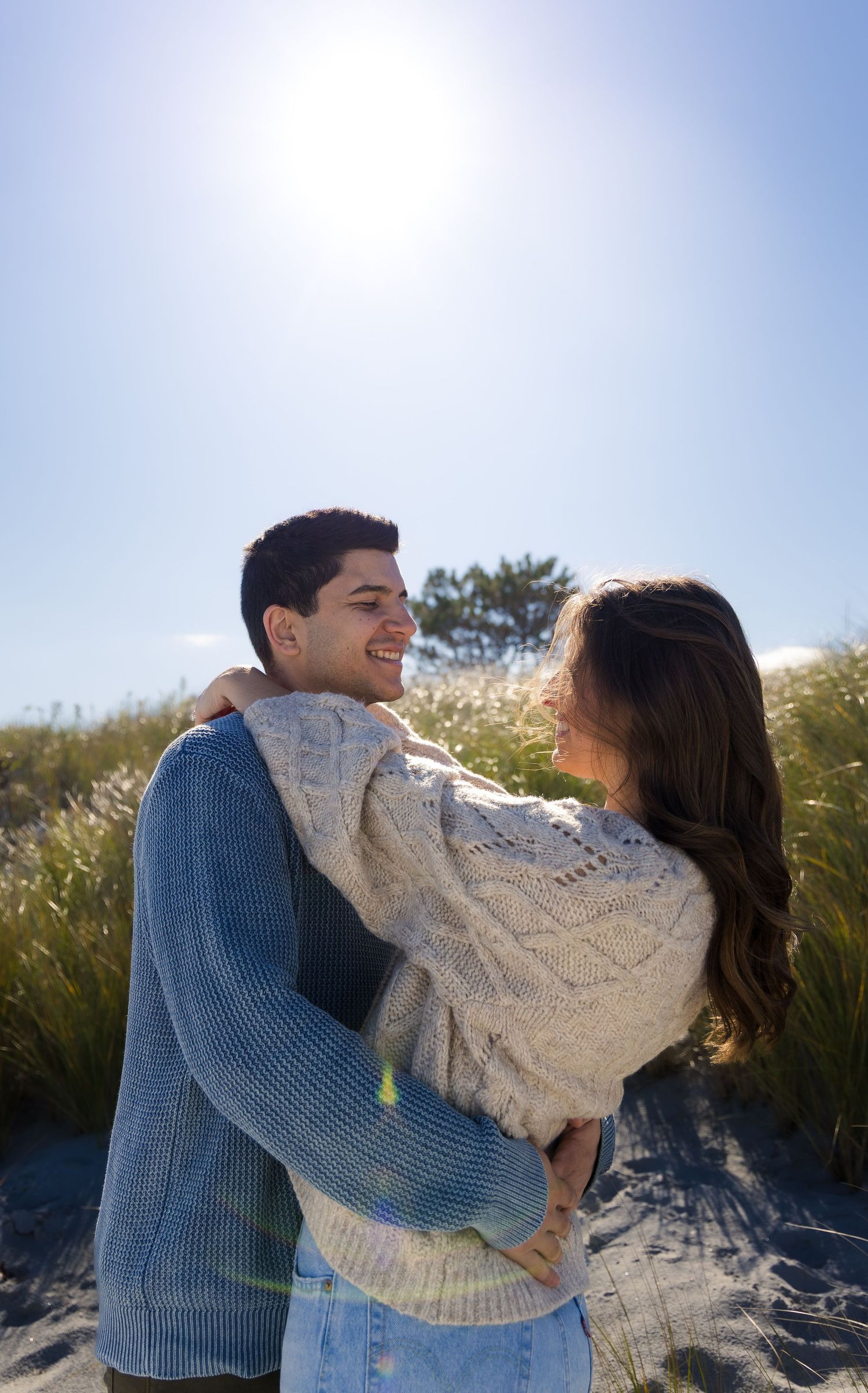 Glowing sunshine engagement photoshoot with couple looking at each other and dancing in each others arms