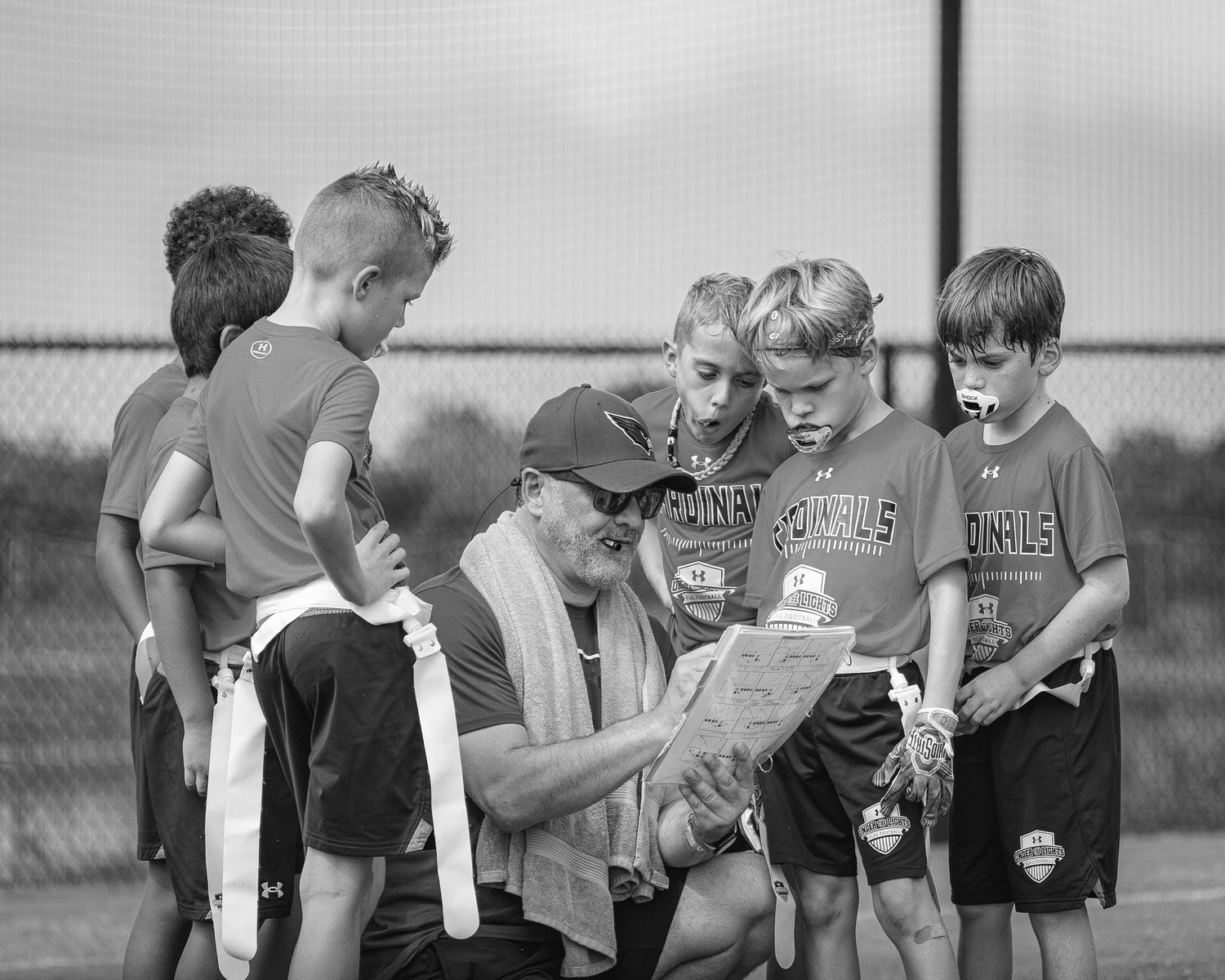 Group of young athletes in matching uniforms gathered on a sports field.