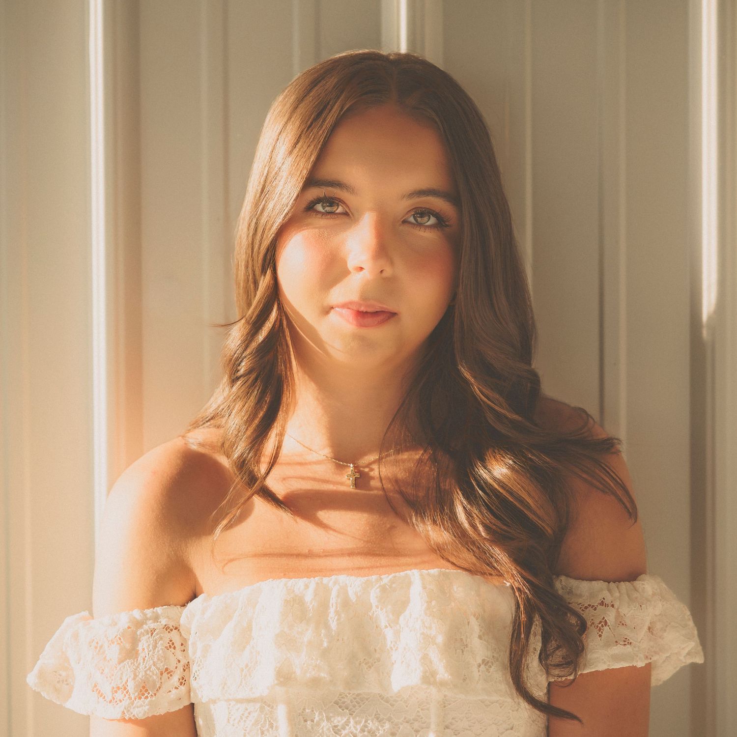 Portrait series showcasing an off-shoulder white lace dress with styled wavy hair.