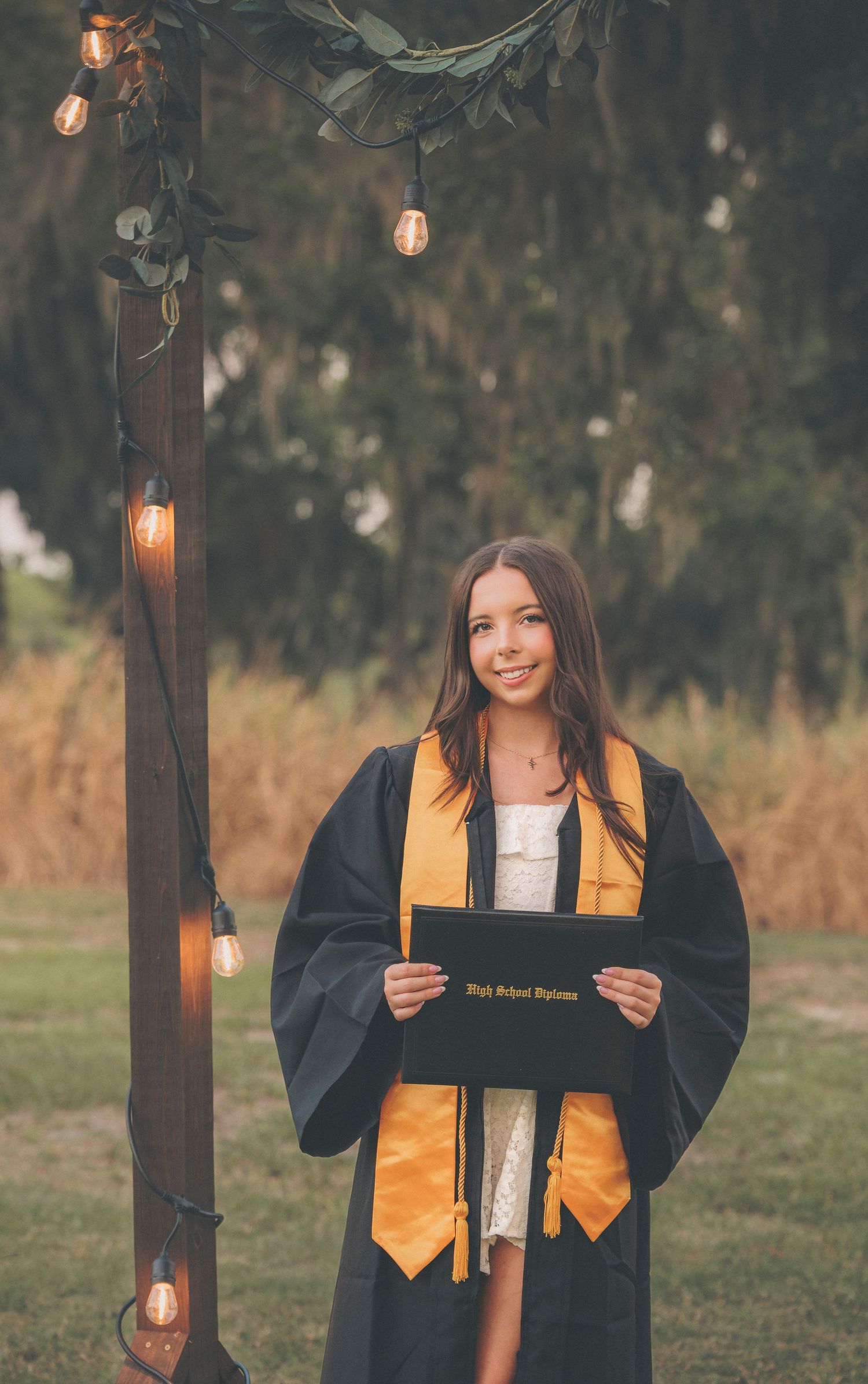 Graduation photos showing someone in gold and black academic regalia outdoors with string lights.
