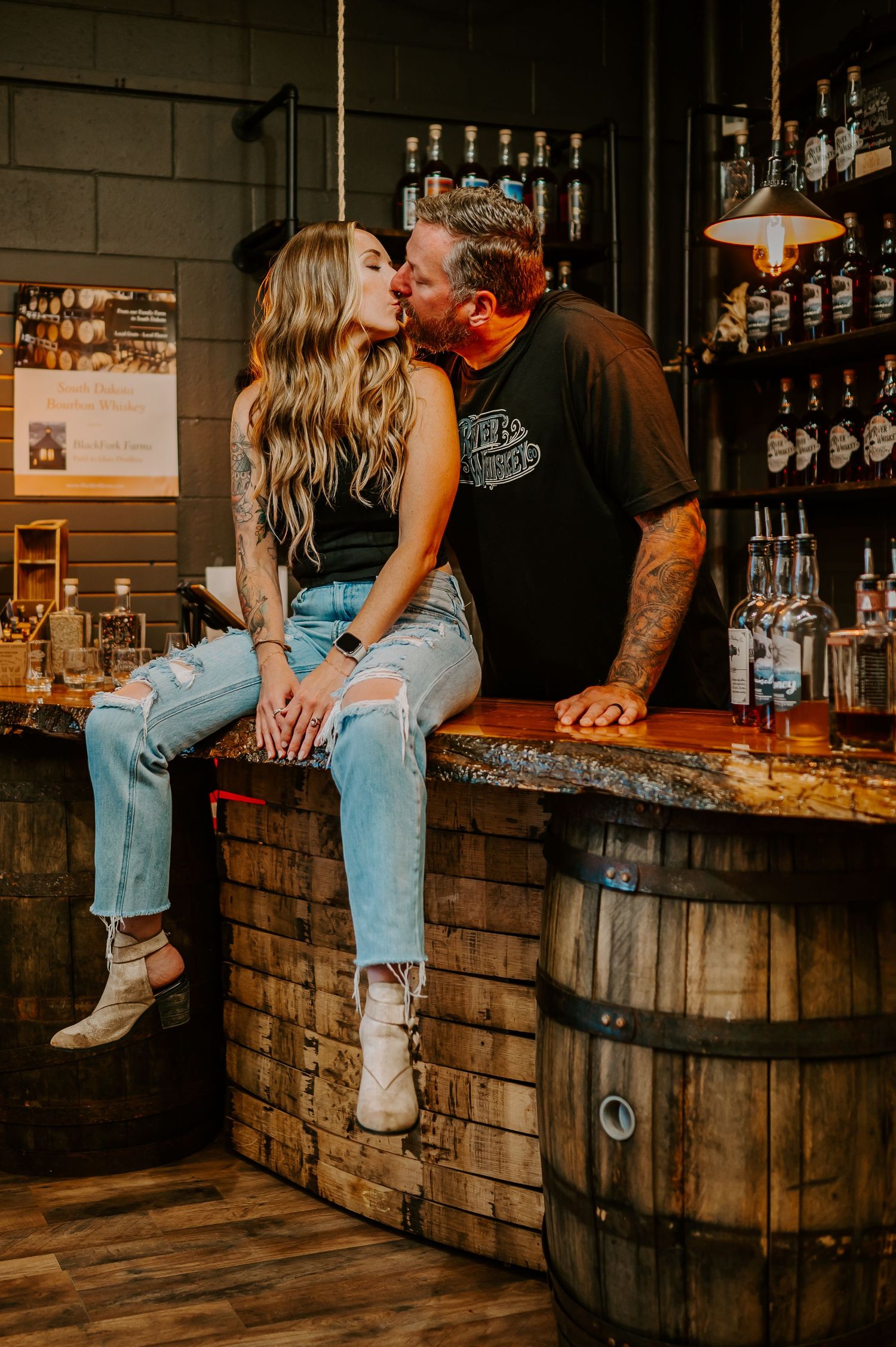 A couple kissing in their distillery bar