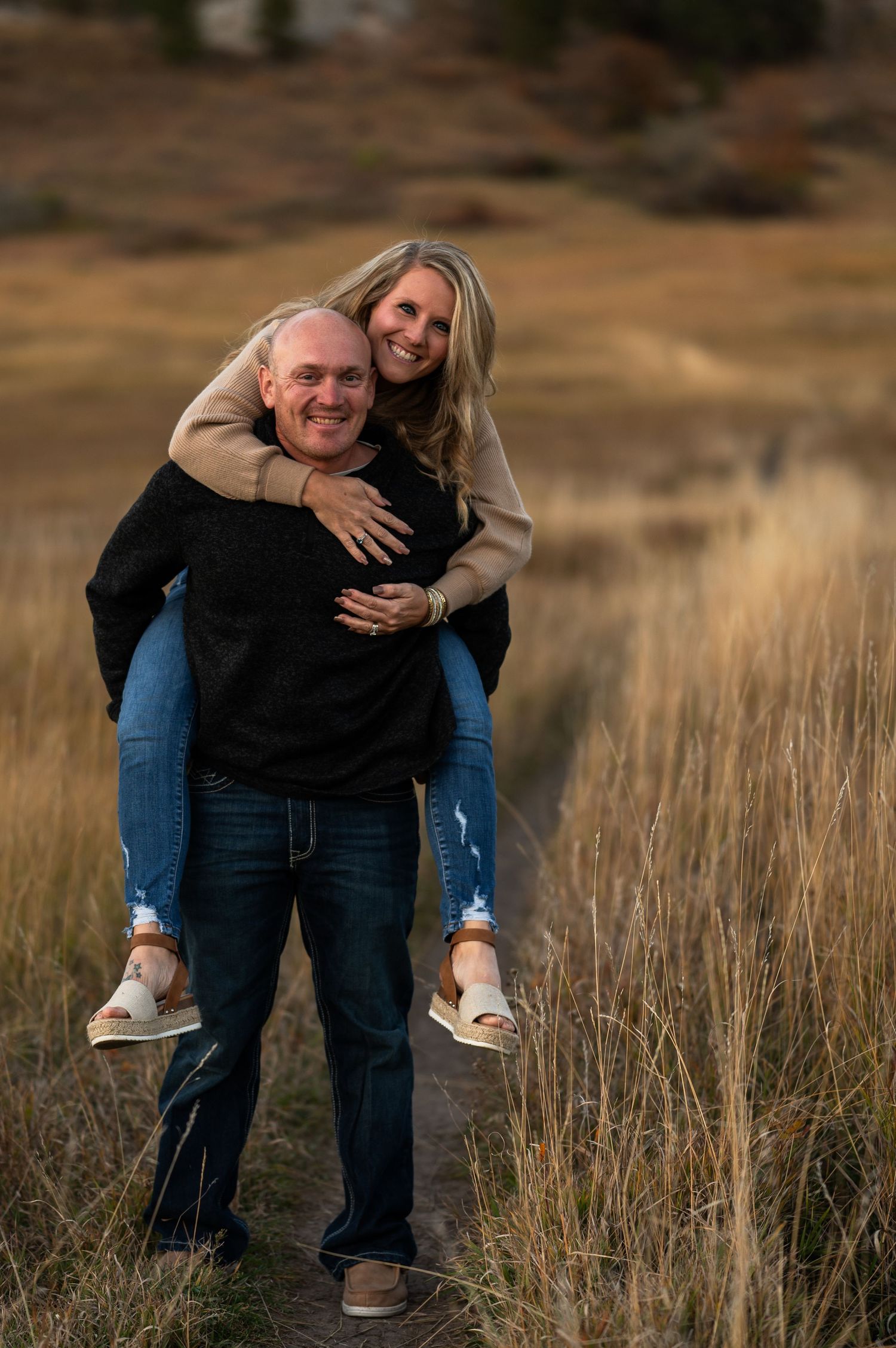 A couple being silly outdoor in a golden field