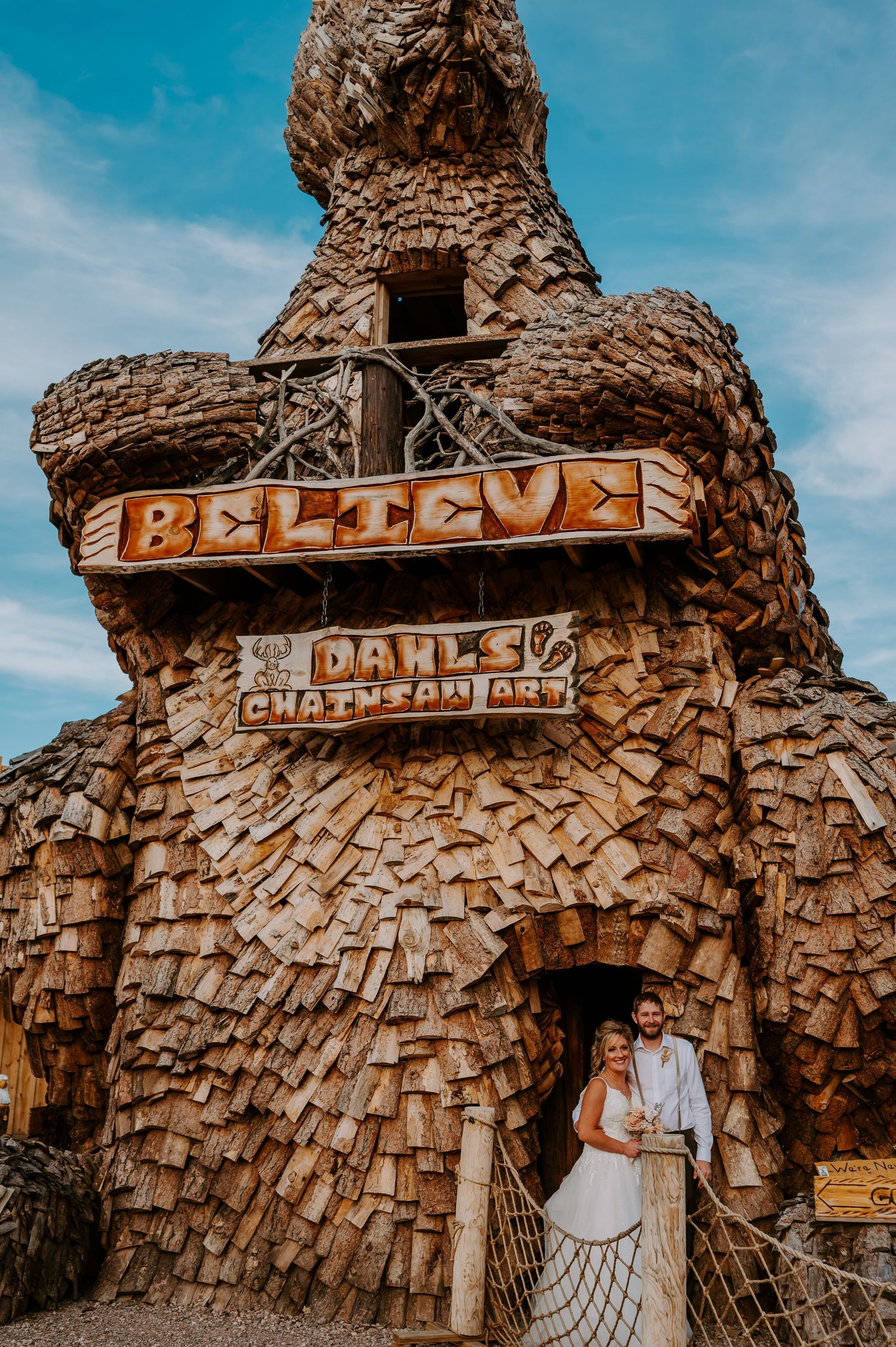 Rustic wooden entrance with woven texture against blue sky in Wall, South Dakota, forming a natural archway design.