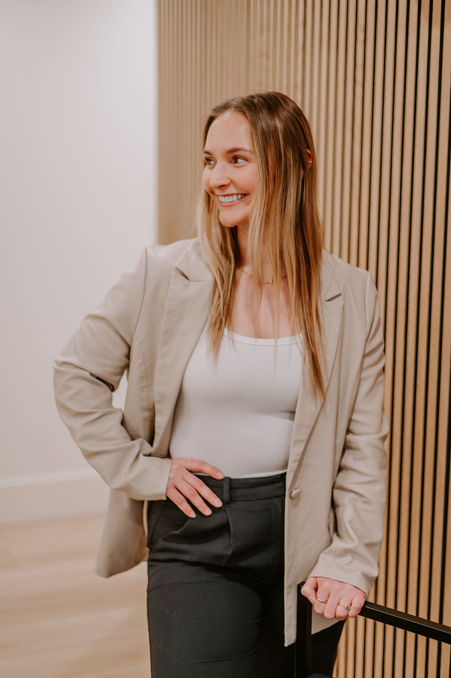Indoor portrait sequence showing person in beige blazer posing against wooden wall panels.