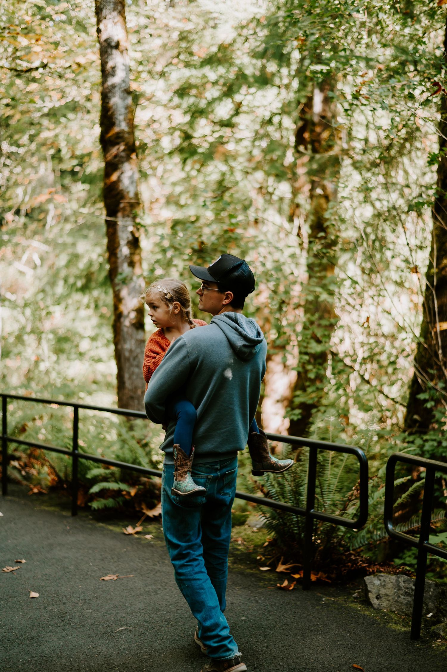 A series of photos showing someone walking down a wooded trail with rustic wooden railings.