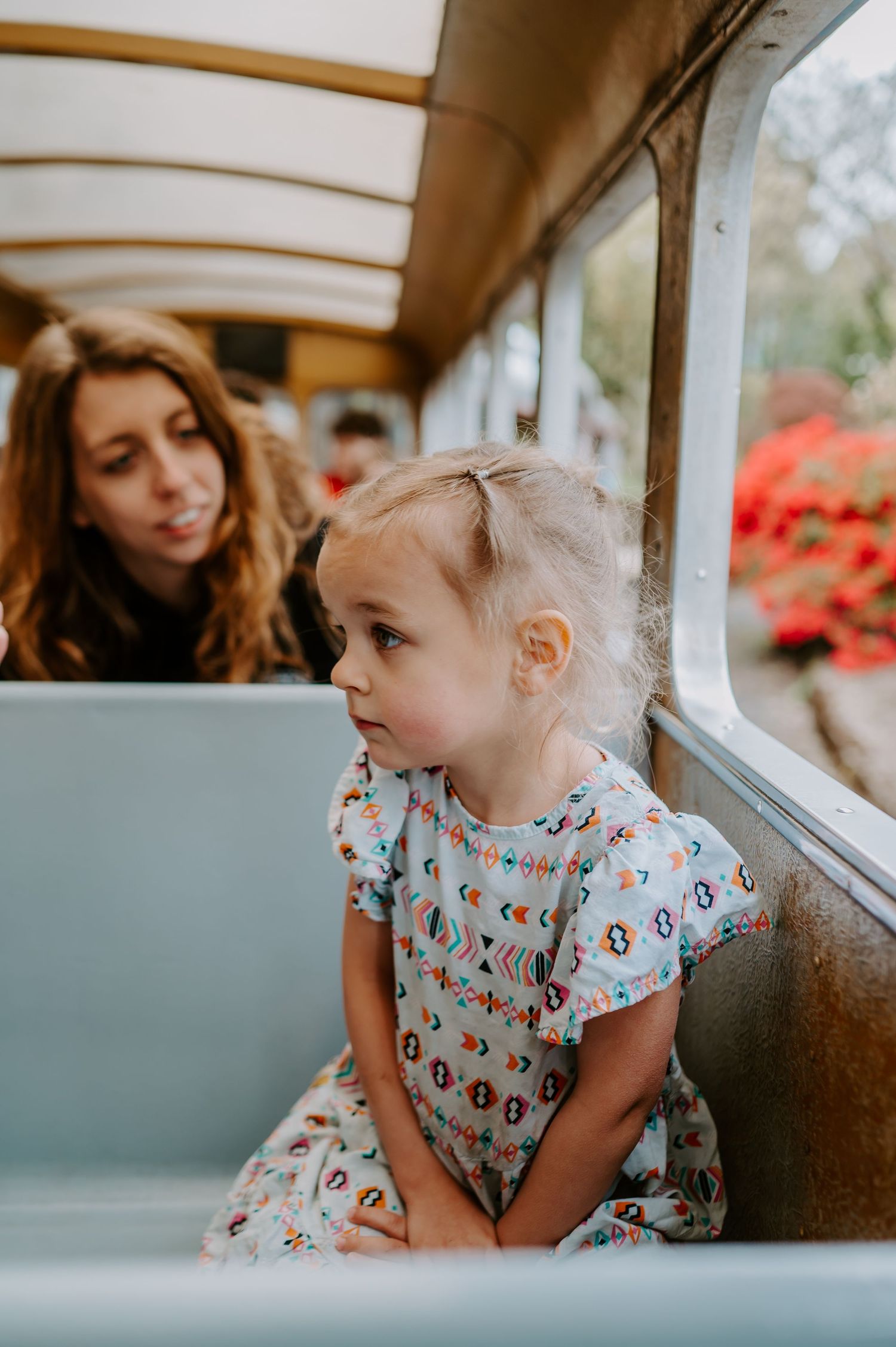 Close up shots of a child looking out a window of a vehicle wearing a patterned shirt.