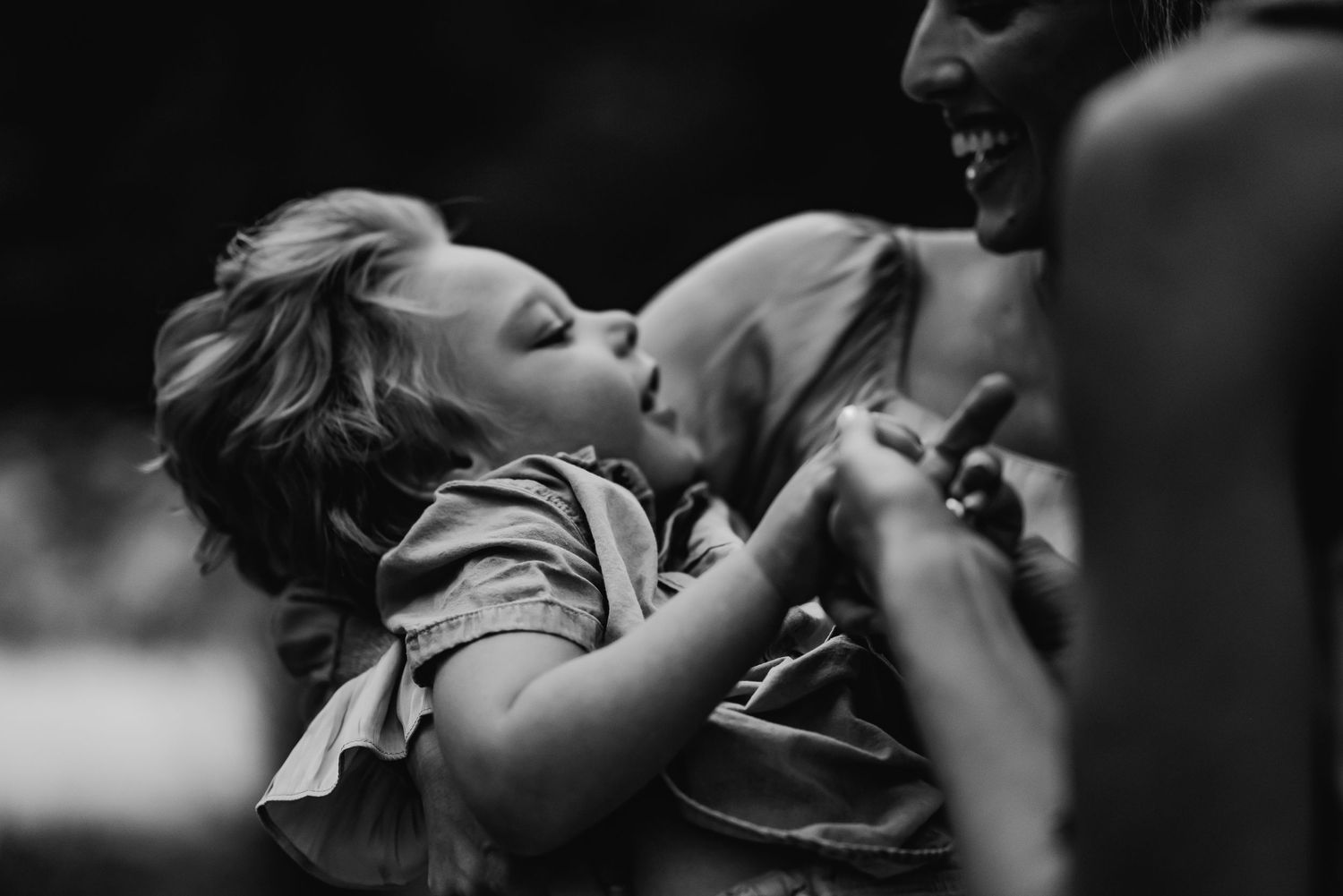 A child and his friend laughing together and holding hands