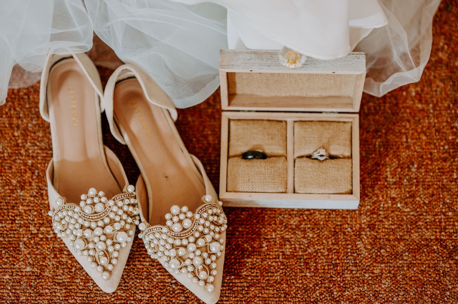 Wedding rings in a decorative box, and pearl adorned wedding shoes