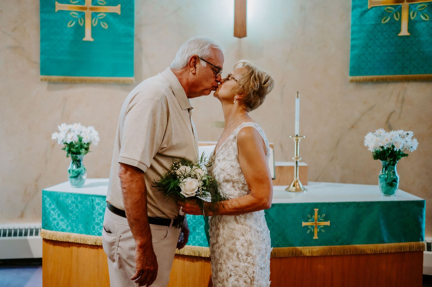 A couple who just got married kissing on the stage of their church