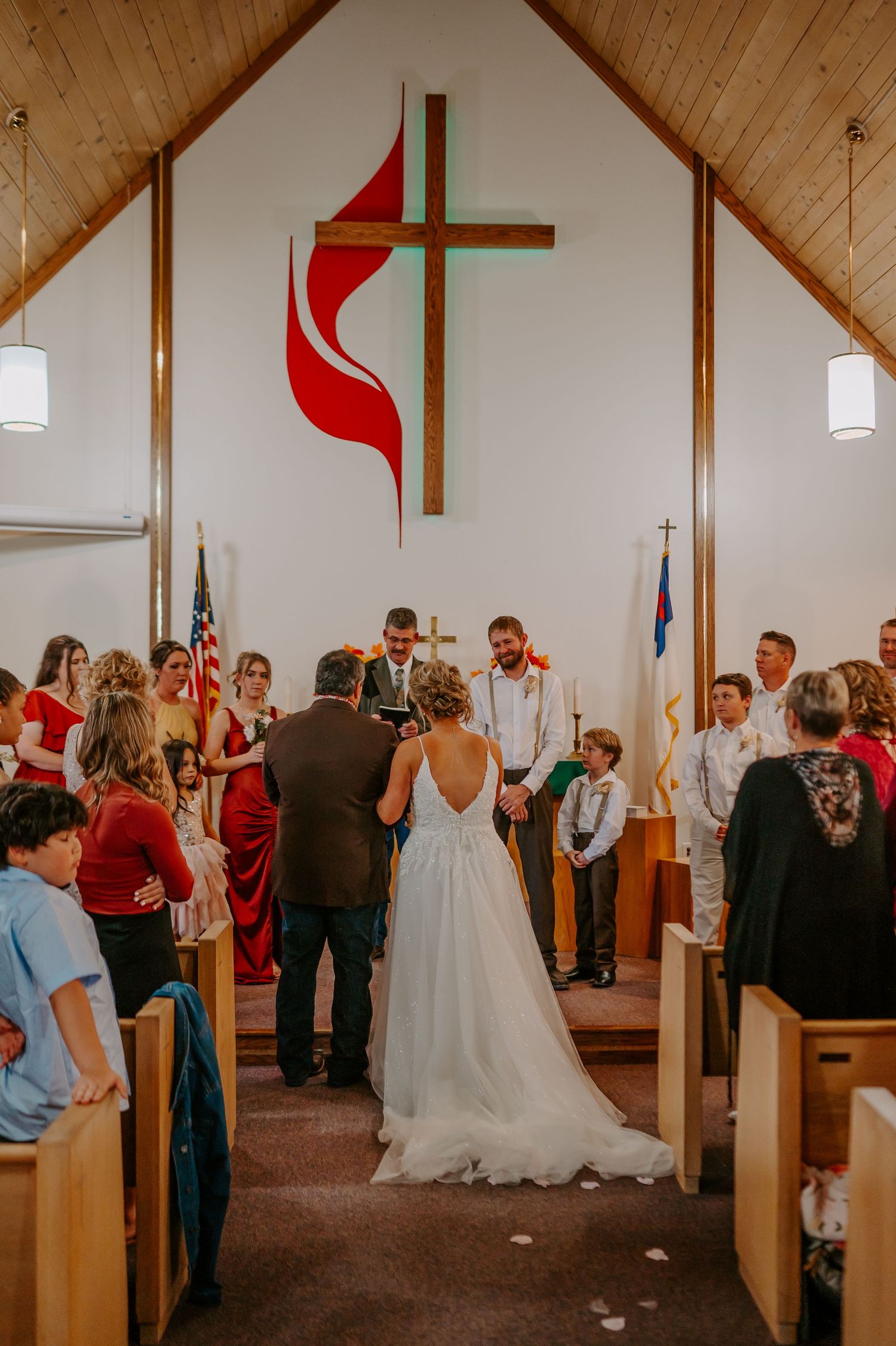 Wedding party lines church aisle and celebrates with joyful guests during traditional church ceremony.