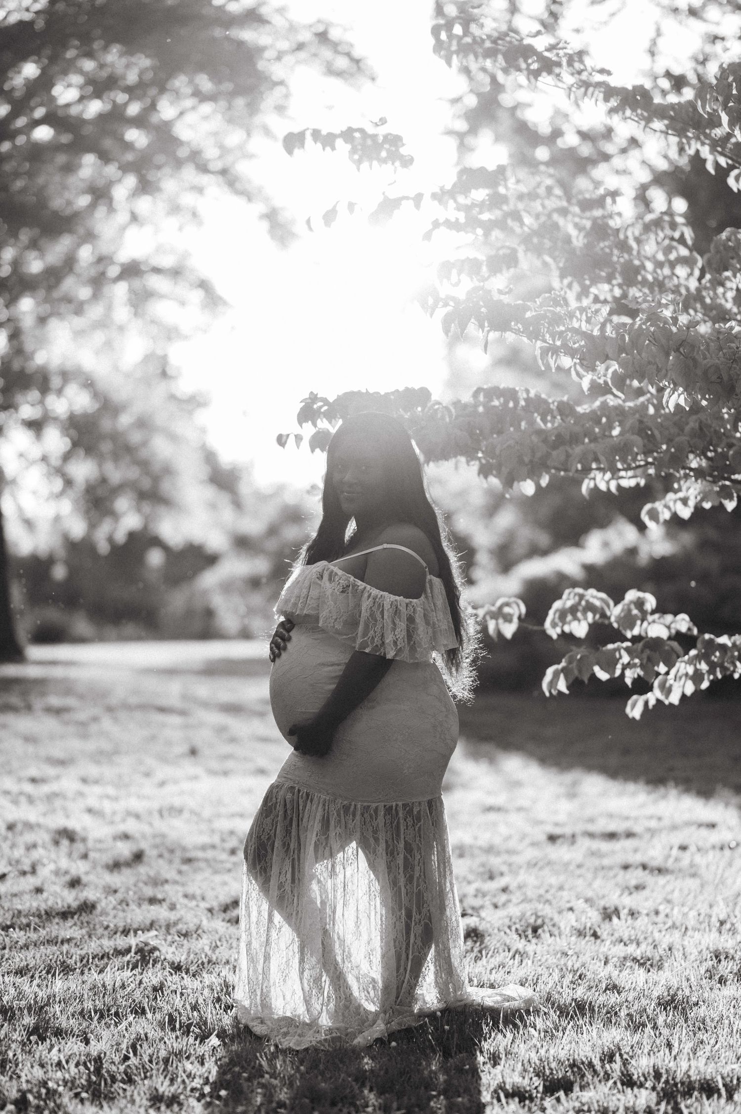 Artistic black and white portrait series captured in a natural outdoor setting with soft backlighting.