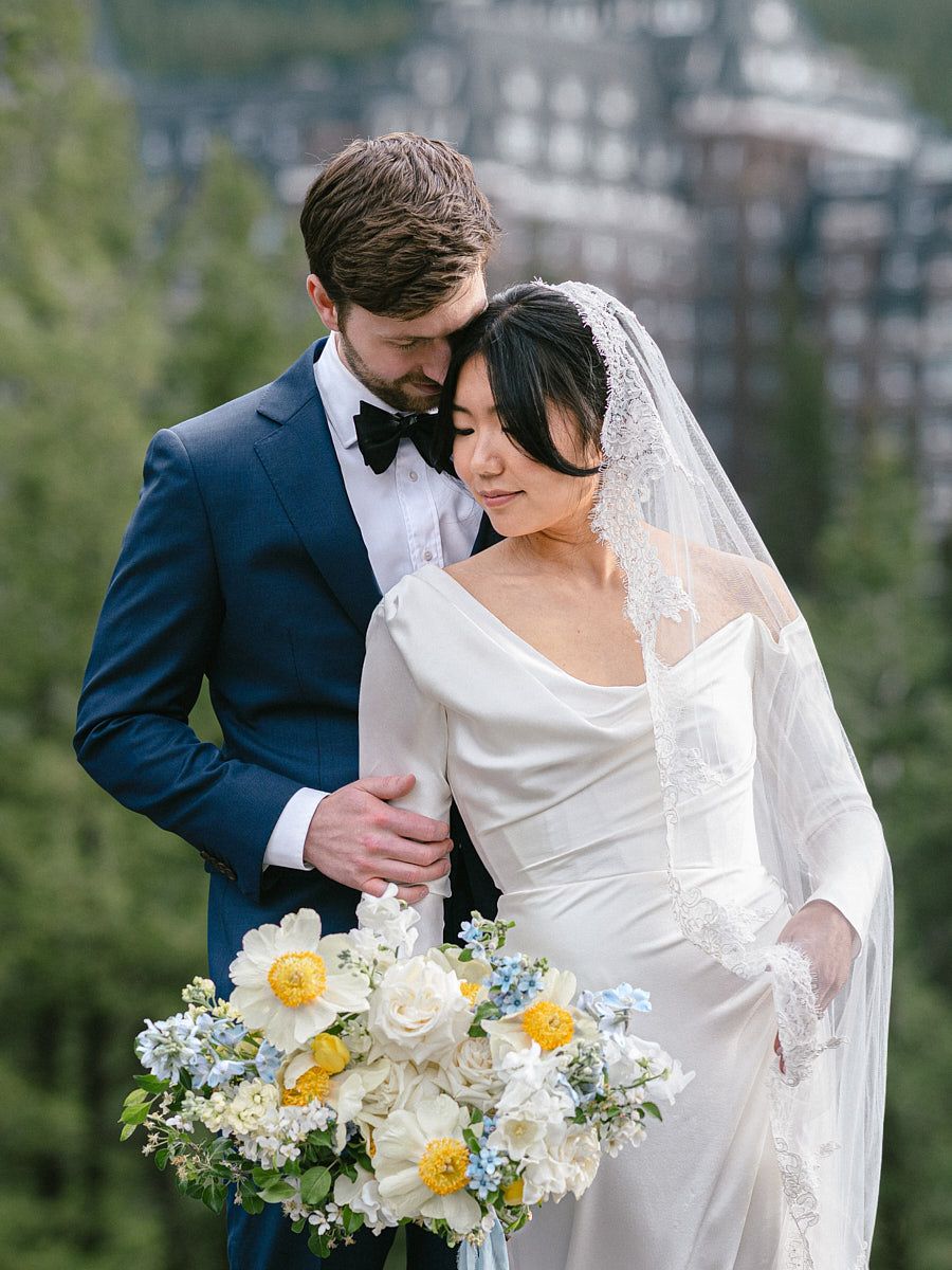 Scenic forest and castle setting highlighting bride and groom in wedding attire