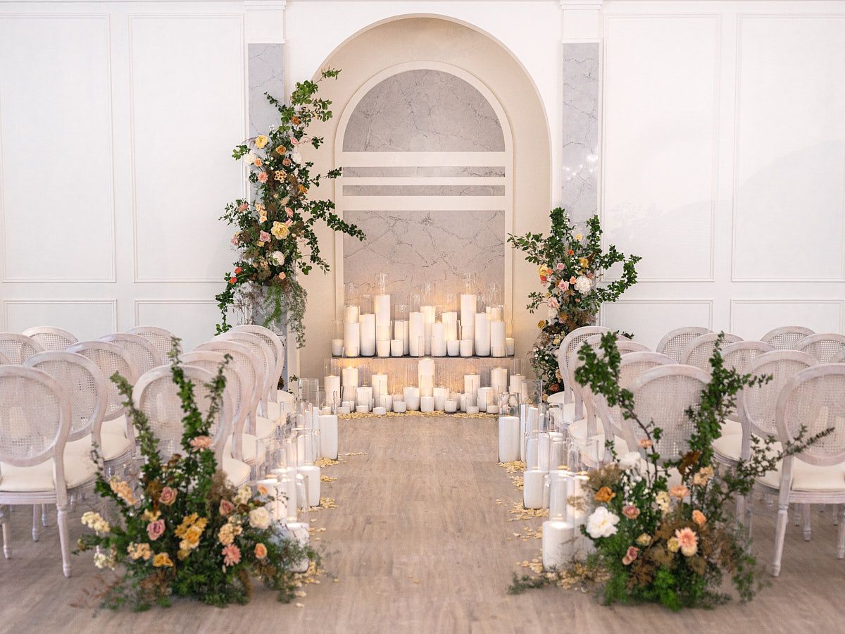 Romantic wedding ceremony arch surrounded by glowing candles, intimate Riga indoor venue ambiance