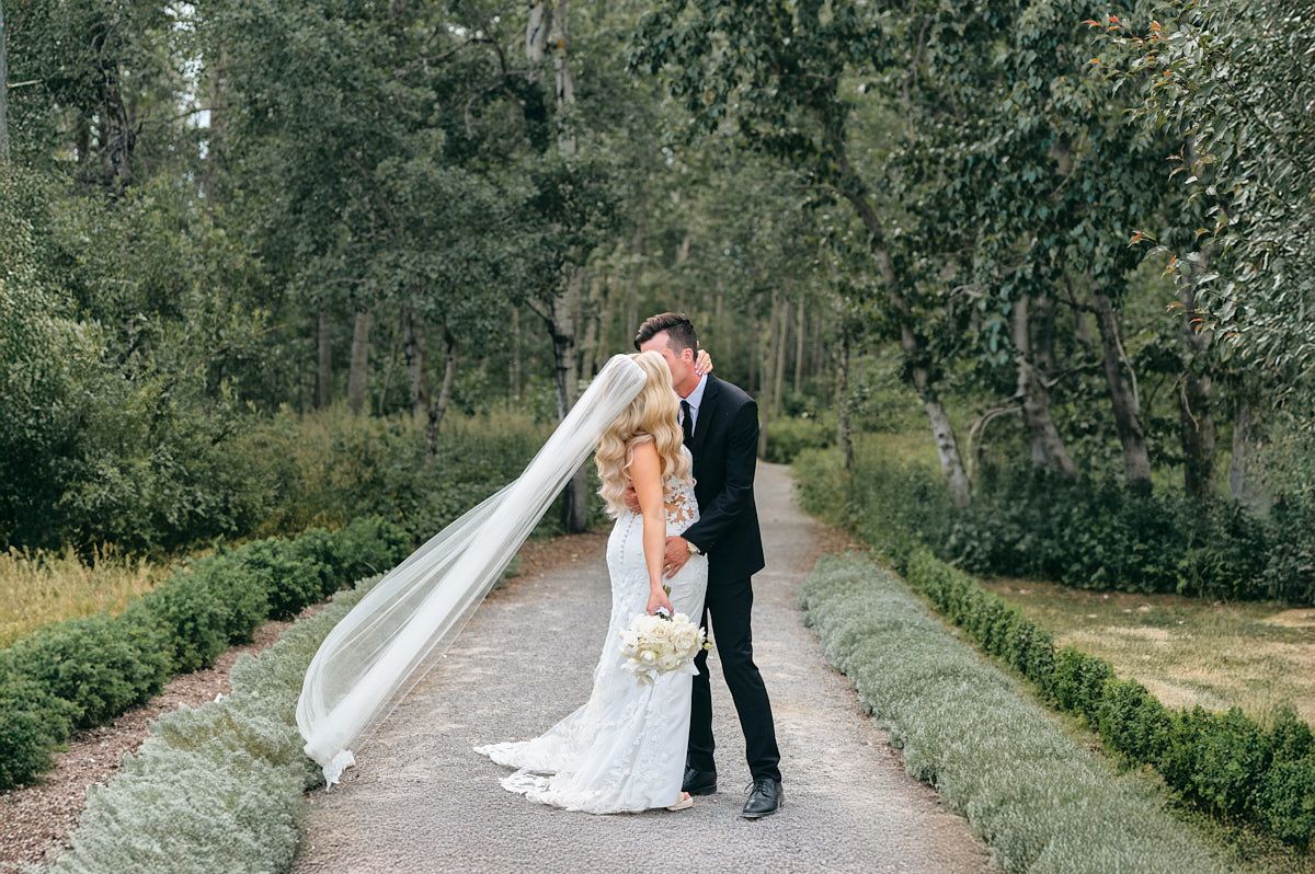 The couple steals a kiss near the vintage-inspired lamp posts lining Latvian venue pathways.
