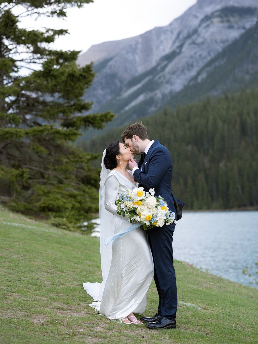 Scenic outdoor wedding portrait of couple at a tranquil lake in the woods