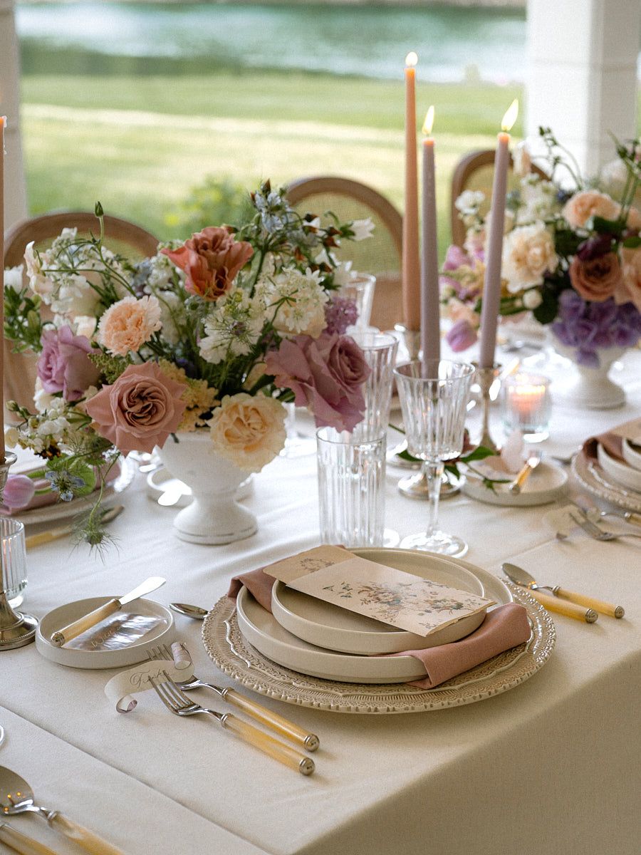 Beautiful pastel wedding table setup highlighting floral arrangements and tableware