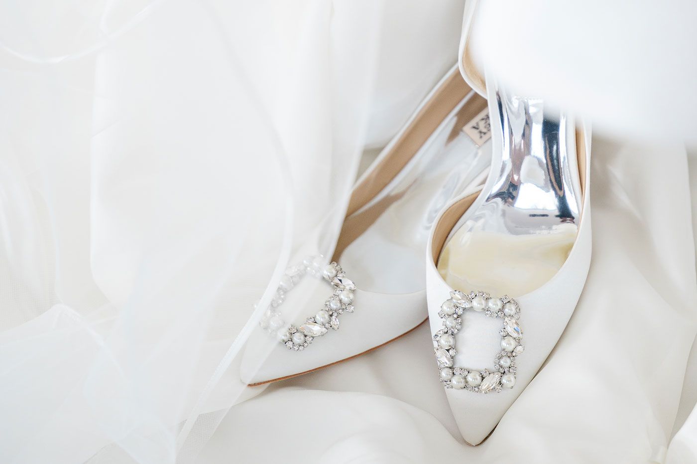 Luxury bridal Badgley Mischka shoes elegantly placed on a flowing veil for a wedding in Riga, Latvia