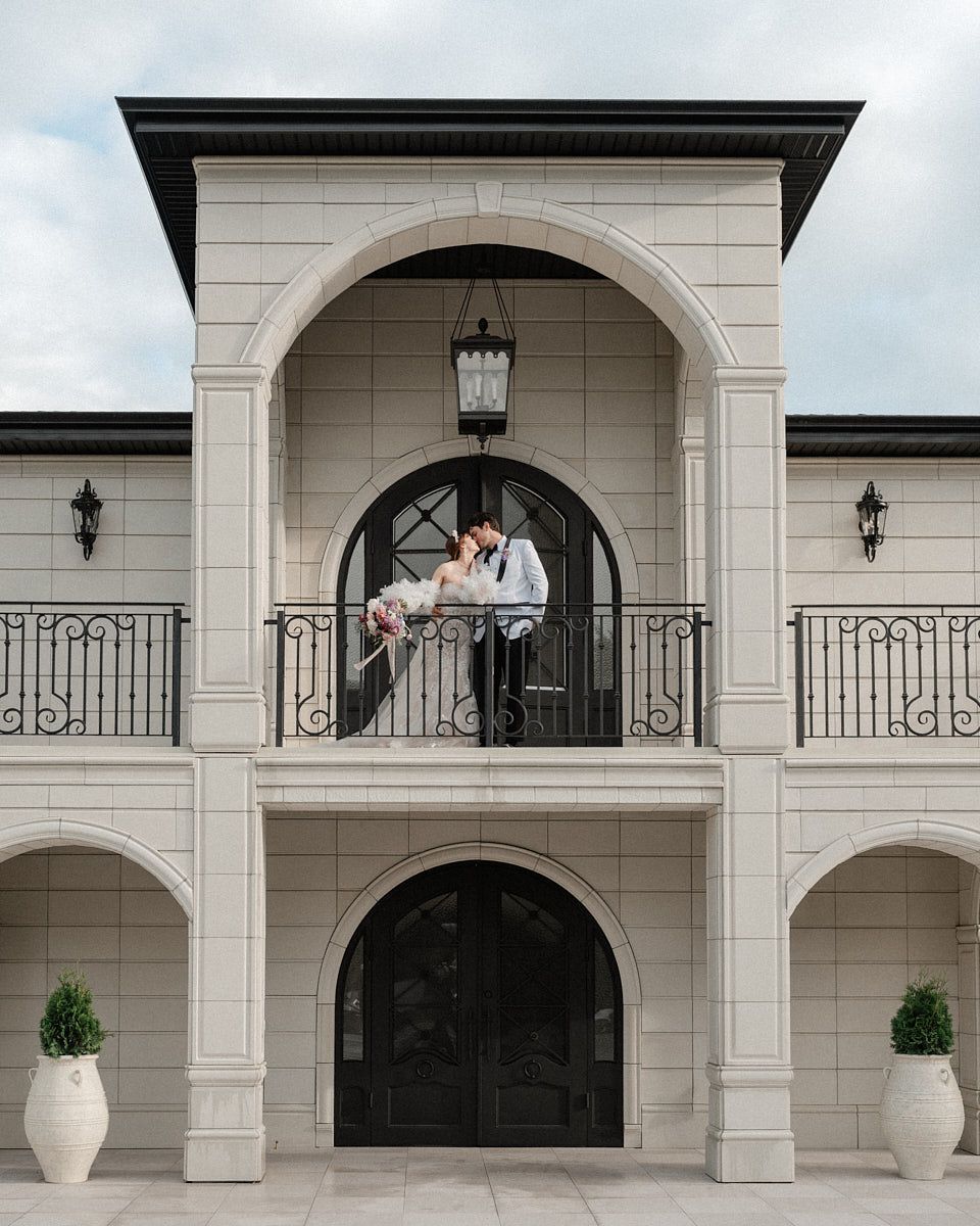 Romantic bride and groom sharing a quiet moment on manor balcony, perfect for Riga wedding photography