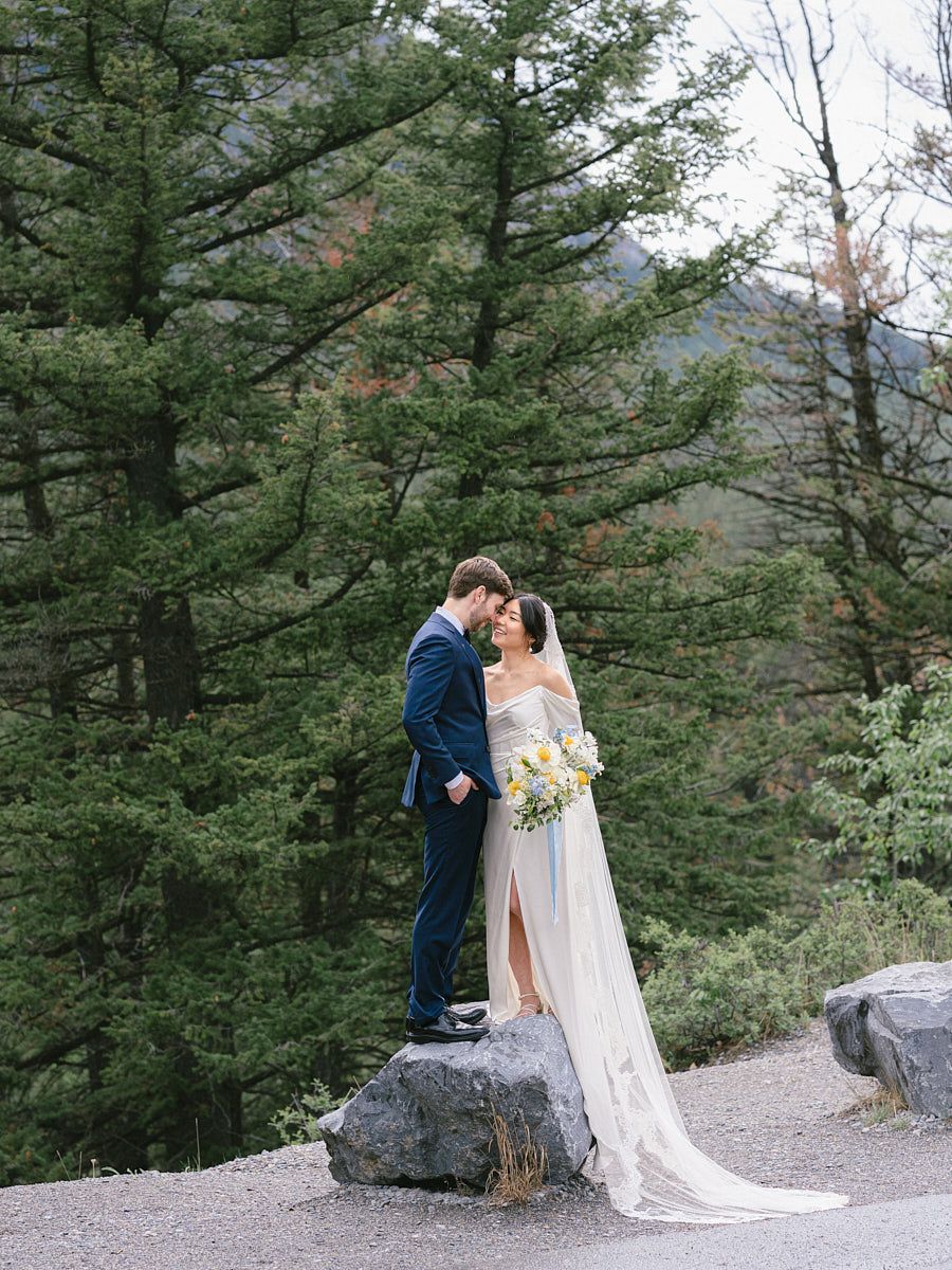 Stunning wedding couple portrait with historic castle framed by woodland scenery