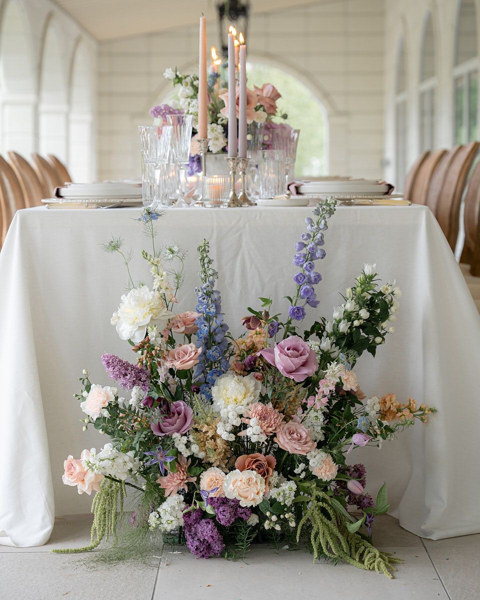 Elegant pastel wedding table setting with florals, plates, and glassware, perfect for Riga weddings