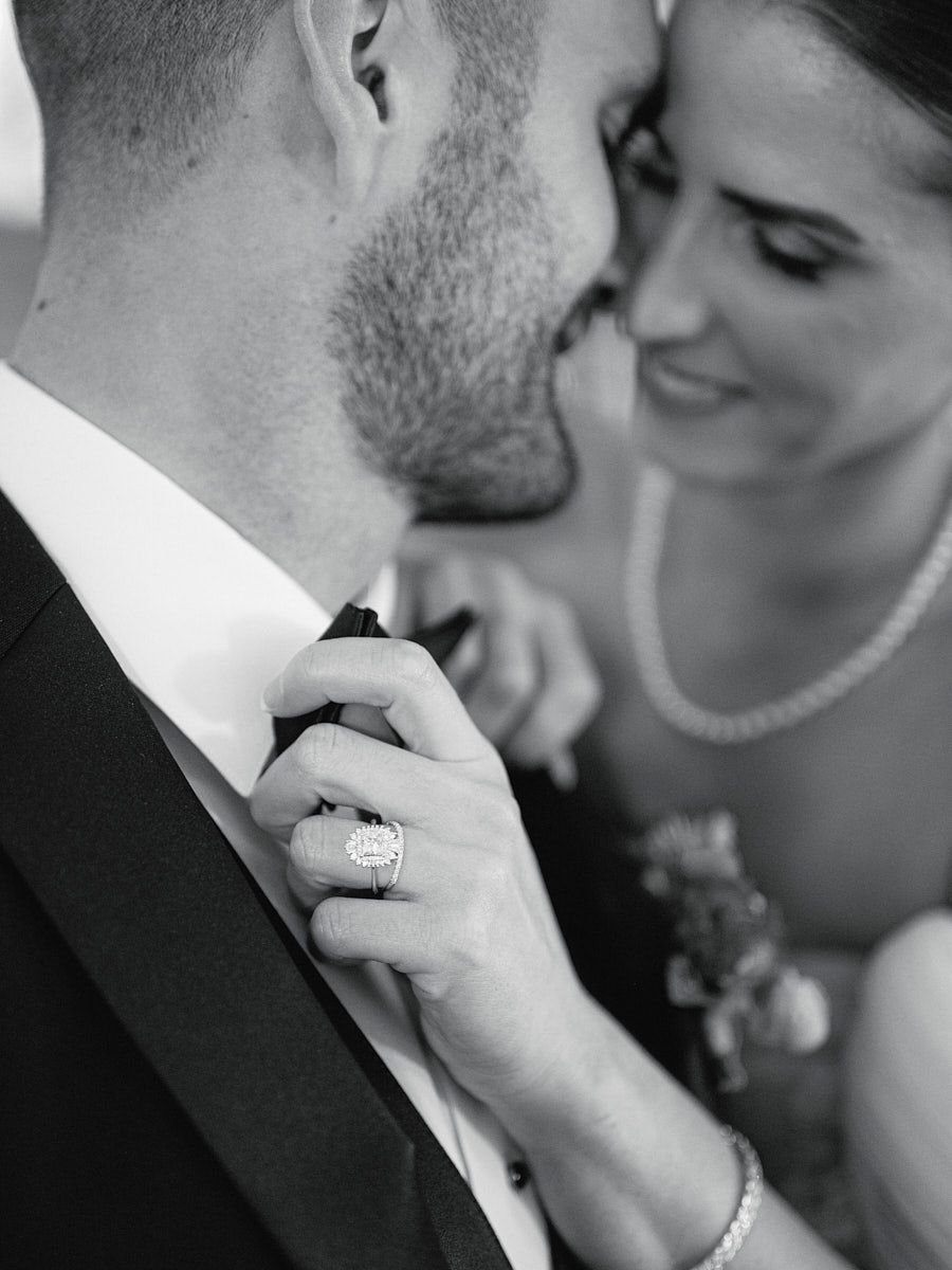 Intimate Riga wedding moment as bride lovingly fixes groom’s bowtie and shares a kiss