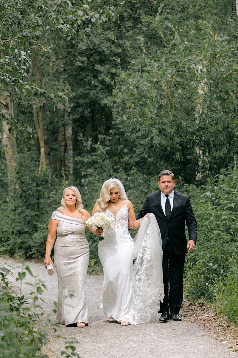 Parents walking their daughter to wedding ceremony, capturing heartfelt Riga wedding moments