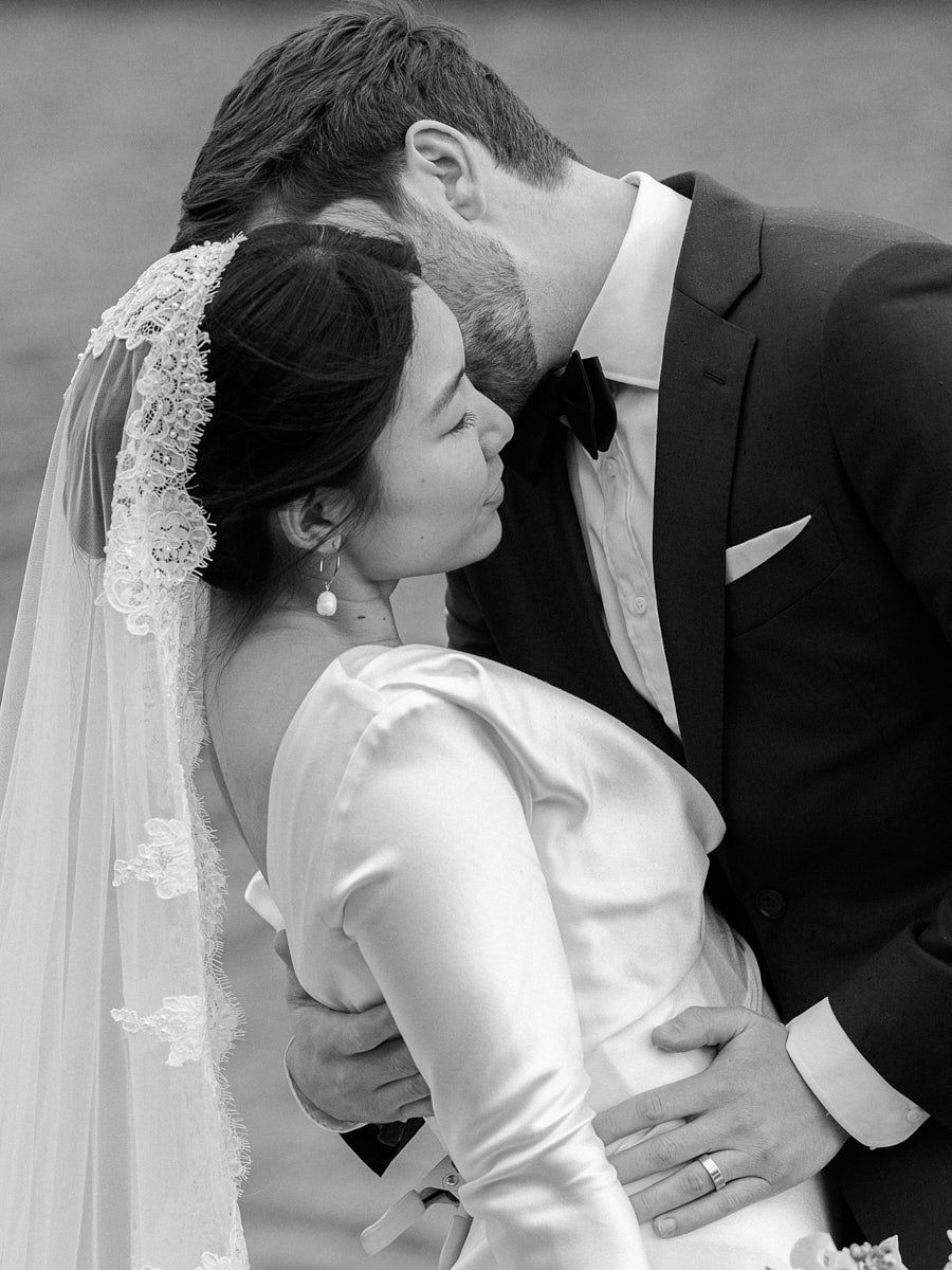 Intimate bride and groom moment by a calm forest lake, captured for Riga weddings
