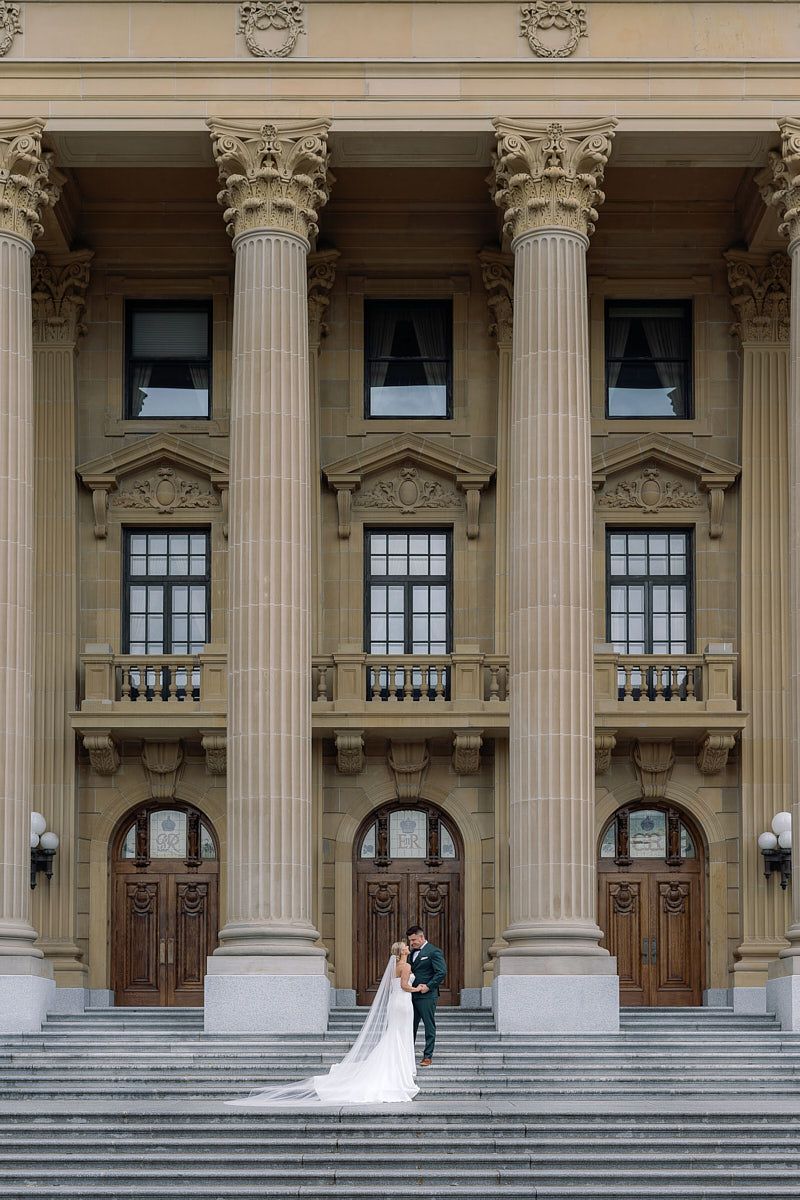 Romantic Riga wedding portrait of bride and groom framed by grand columns