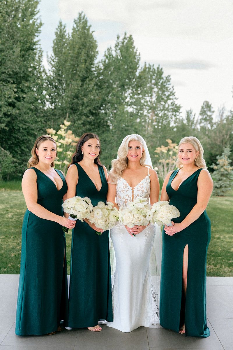 Bride posing with bridesmaids in green dresses, capturing stylish Riga wedding party moments