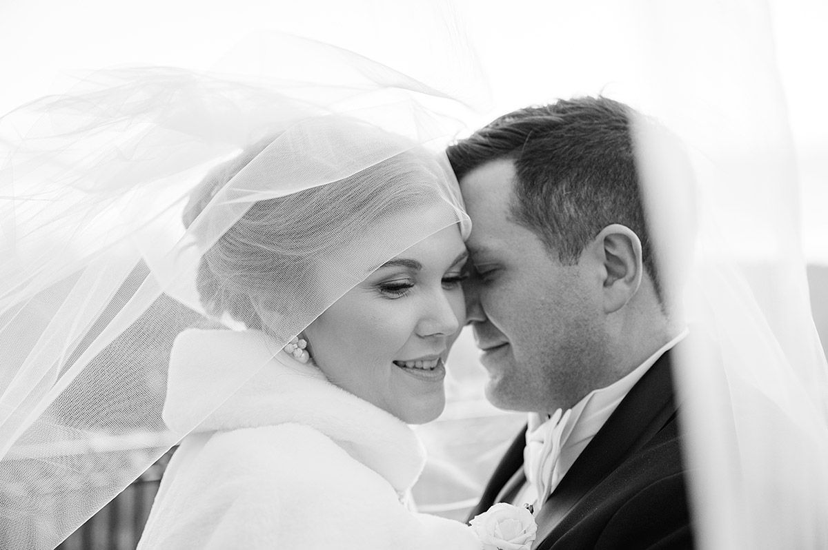 Intimate wedding portrait of bride and groom under the veil during Riga ceremony