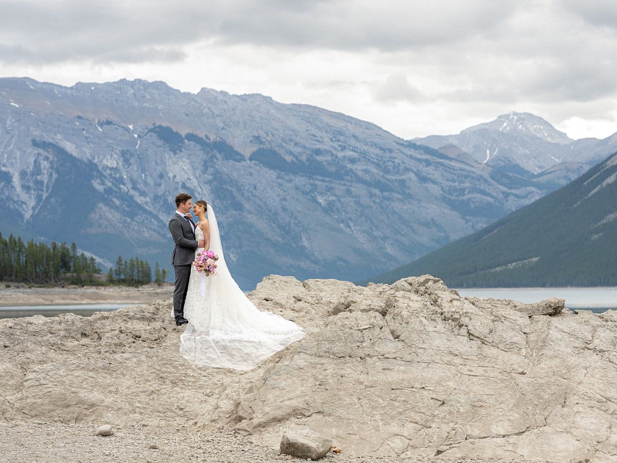 Bride and groom embracing near a scenic mountain lake, ideal Riga wedding inspiration