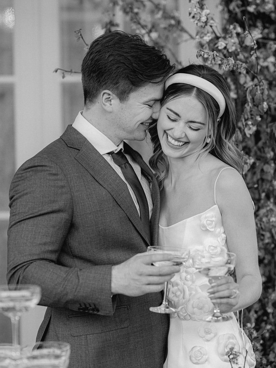 Bride and groom enjoying champagne at Riga wedding with glass tower