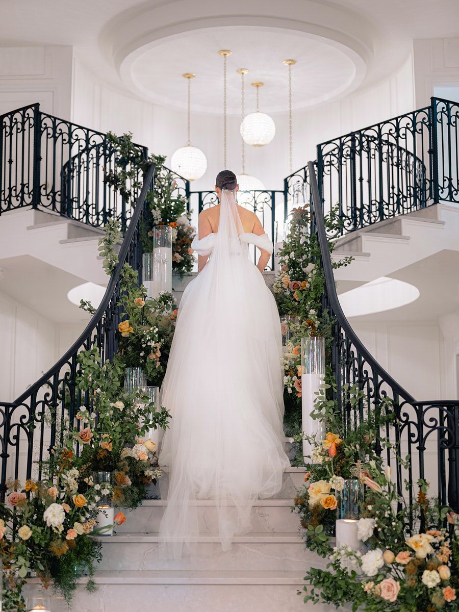 Stunning bride on ornate staircase, elegant Riga wedding photography capturing graceful movement